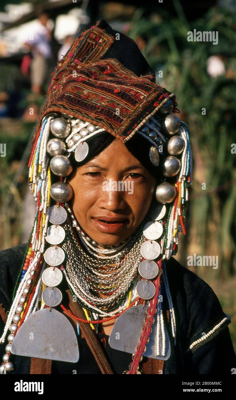 Thailand: Elaborately bejewelled Akha woman, Chiang Rai.  The Akha are a hill tribe of subsistence farmers known for their artistry. The ethnic group may have originated in Mongolia around 1500 years ago. Most of the remaining Akha people are now distributed in small villages among the mountains of China, Laos, Myanmar (Burma), and northern Thailand, where they are one of the six main hill tribes. The Akha began arriving in Thailand in the early twentieth century and continue to immigrate, with some 80,000 now living in Thailand's northern provinces of Chiang Rai and Chiang Mai. Stock Photo