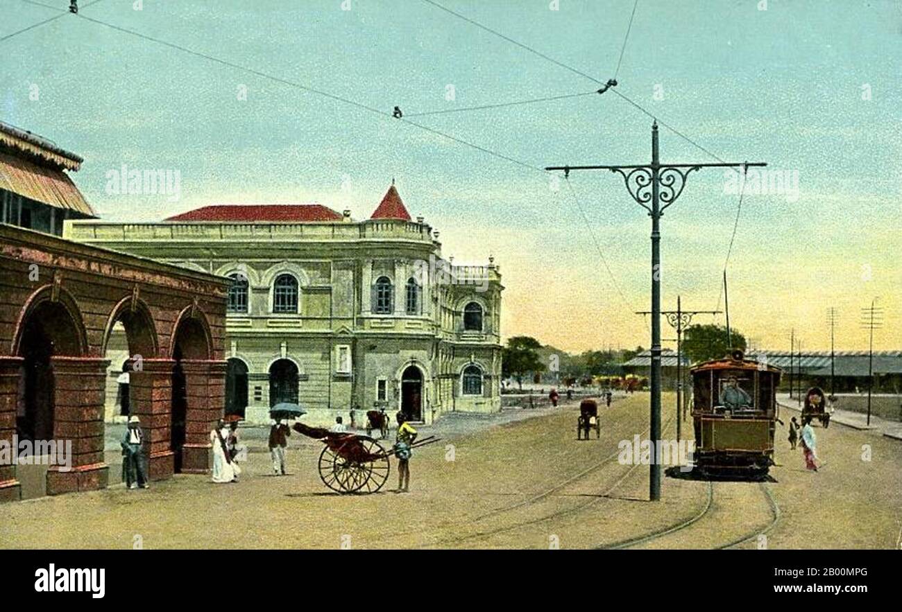 Sri Lanka: Tram and Rickshaw on Chatham Street, Colombo, c. 1900.  Colombo is the largest city and former capital of Sri Lanka. It is located on the west coast of the island, adjacent to Sri Jayawardenapura Kotte, the capital. Colombo is a busy and vibrant city with a mixture of modern life and colonial buildings and ruins. It has a city population of 647,100 (2010). Due to its large harbour and its strategic position along the East-West sea trade routes, Colombo was known to ancient traders 2,000 years ago. Stock Photo