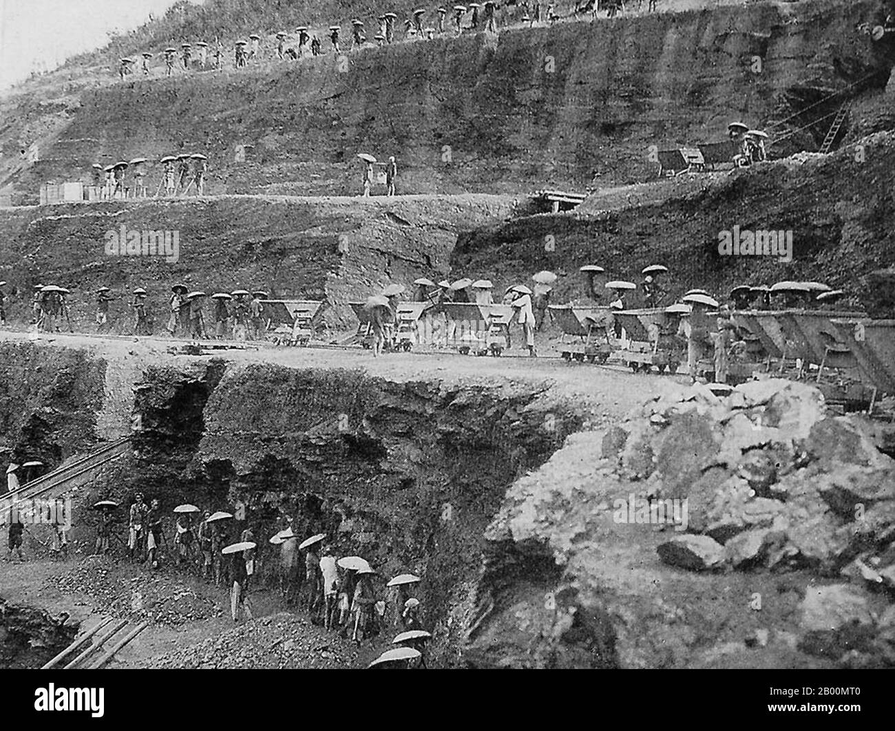 Vietnam: Coal workers in the strip mines at Hon Gai, near Halong,  c. 1900.  Hon Gai (now part of Ha Long City) is part of the capital city of Quảng Ninh Province. The city mainly lies on Bai Tu Long Bay, which adjoins Hạ Long Bay. It is located at about 160 km northeast of Hanoi. Hong Gai has long been the main source of surface coal in Vietnam, and its strip mines, especially during the colonial period, were infamous for their hard conditions approaching near slave labour. Hạ Long city is divided into two parts: East Hạ Long and West Hạ Long. Stock Photo