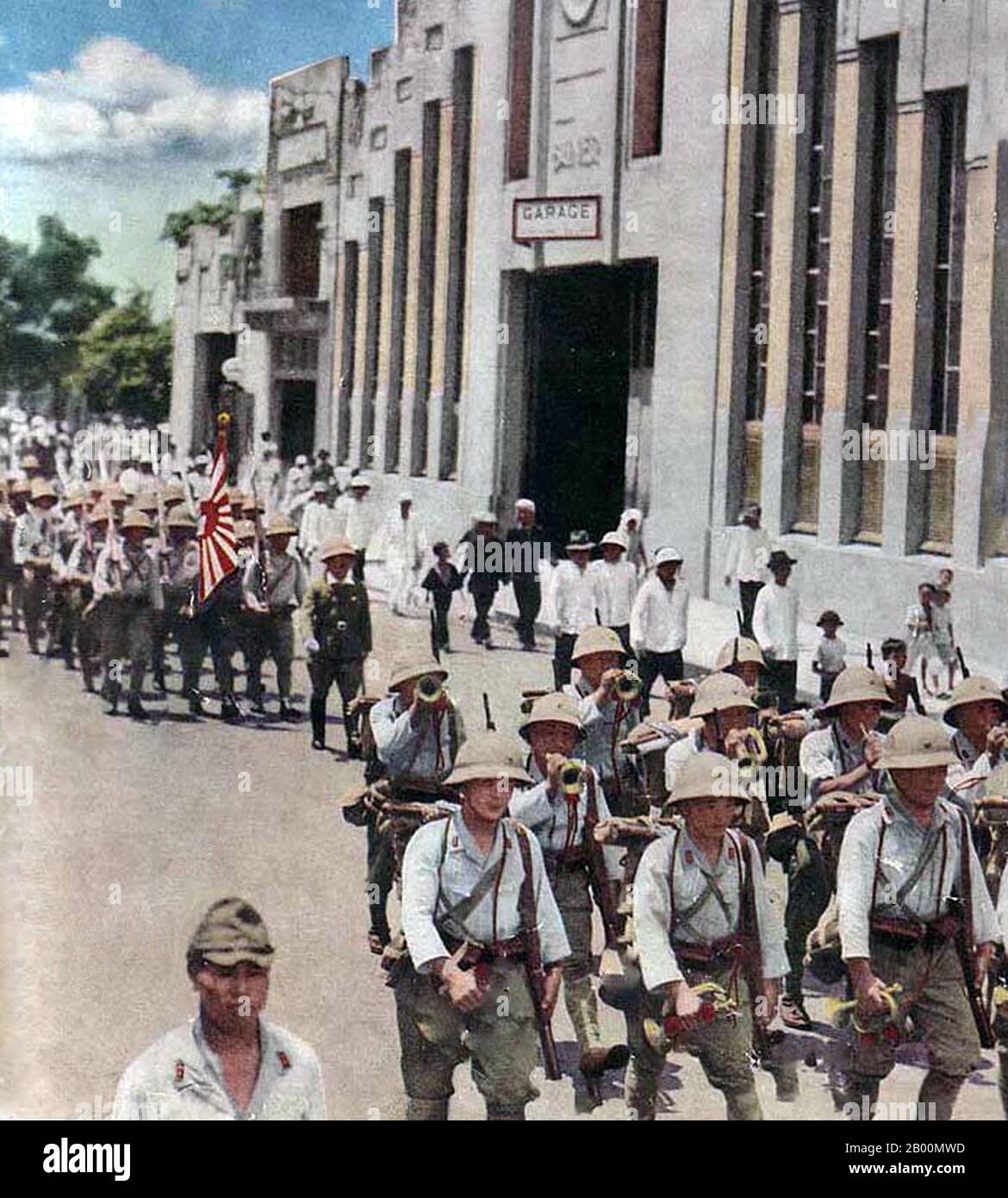 Vietnam: Imperial Japanese troops march through downtown Saigon c. 1944.  The Japanese Invasion of French Indochina, also known as the Vietnam Expedition, was a move by the Empire of Japan in September 1940, during the Second Sino-Japanese War, to prevent China from importing arms and fuel through French Indochina, via the Sino-Vietnamese Railway from the port of Haiphong through Hanoi to Kunming in Yunnan. Japan occupied northern Indochina, which tightened the blockade of China, and made continuation of the drawn out Battle of South Guangxi unnecessary. Stock Photo