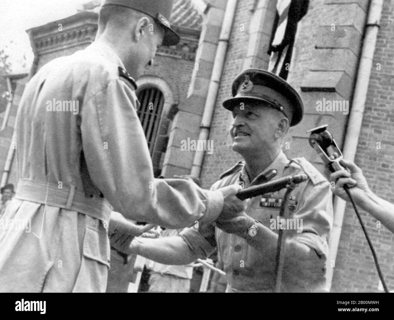 Vietnam: British General Sir Douglas David Gracey (1894–1964) handing over authority to French General Philippe Leclerc outside Saigon Cathedral, 1945.  In September 1945, Gracey led 20,000 troops of the 20th Indian Division to occupy Saigon. During the Potsdam Conference in July 1945, the Allies had agreed on Britain taking control of Vietnam south of the 16th parallel from the Japanese occupiers. The French, anxious to retain their colony, persuaded Gracey's Commander in Chief, Lord Mountbatten, to authorise Gracey to declare martial law. Stock Photo
