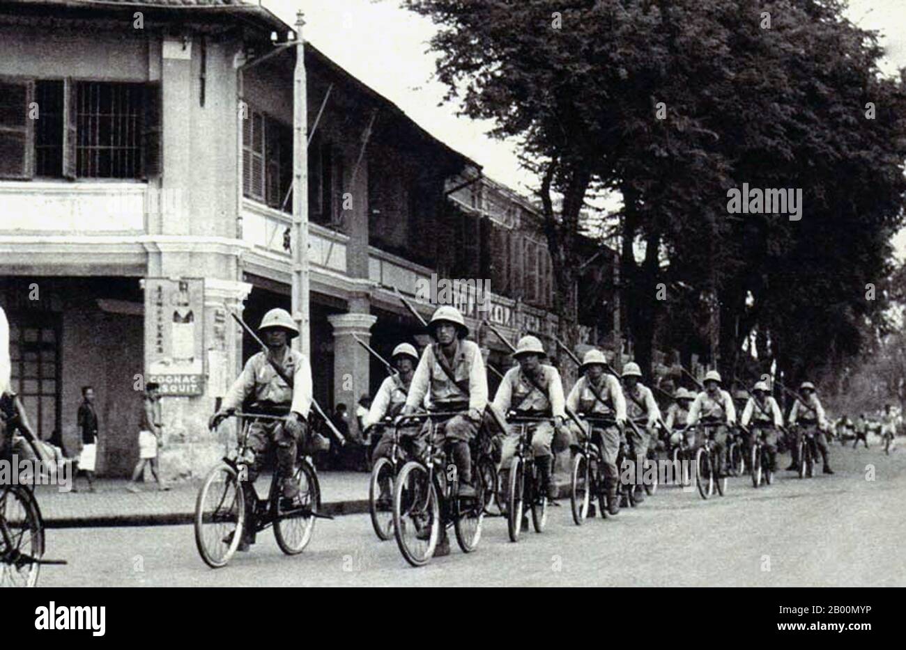 Vietnam: Imperial Japanese Army troops bicycling through Saigon, c. 1942.  The Japanese Invasion of French Indochina, also known as the Vietnam Expedition, was a move by the Empire of Japan in September 1940, during the Second Sino-Japanese War, to prevent China from importing arms and fuel through French Indochina, via the Sino-Vietnamese Railway from the port of Haiphong through Hanoi to Kunming in Yunnan.  Japan occupied northern Indochina, which tightened the blockade of China, and made continuation of the drawn out Battle of South Guangxi unnecessary. Stock Photo