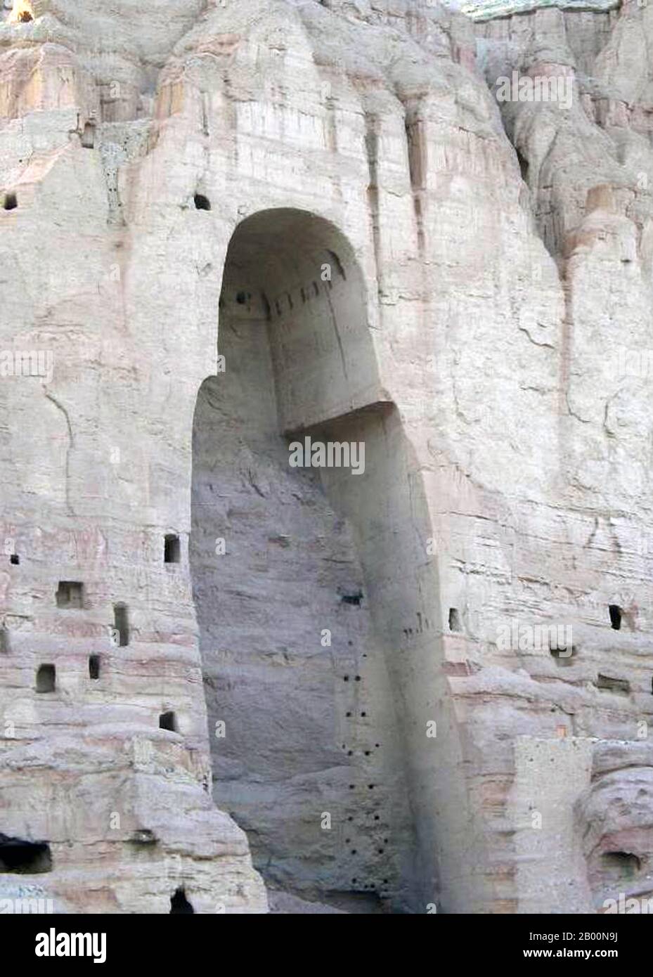 Afghanistan: Bamiyan Buddha cave in 2005 after destruction of Buddha image by Taliban in 2001.  The Buddhas of Bamiyan were two 6th century monumental statues of standing buddhas carved into the side of a cliff in the Bamiyan valley in the Hazarajat region of central Afghanistan, situated 230 km (143 miles) northwest of Kabul at an altitude of 2,500 meters (8,202 ft).  Built in 507 CE, the larger in 554 CE, the statues represented the classic blended style of Gandhara art. The main bodies were hewn directly from the sandstone cliffs. Stock Photo