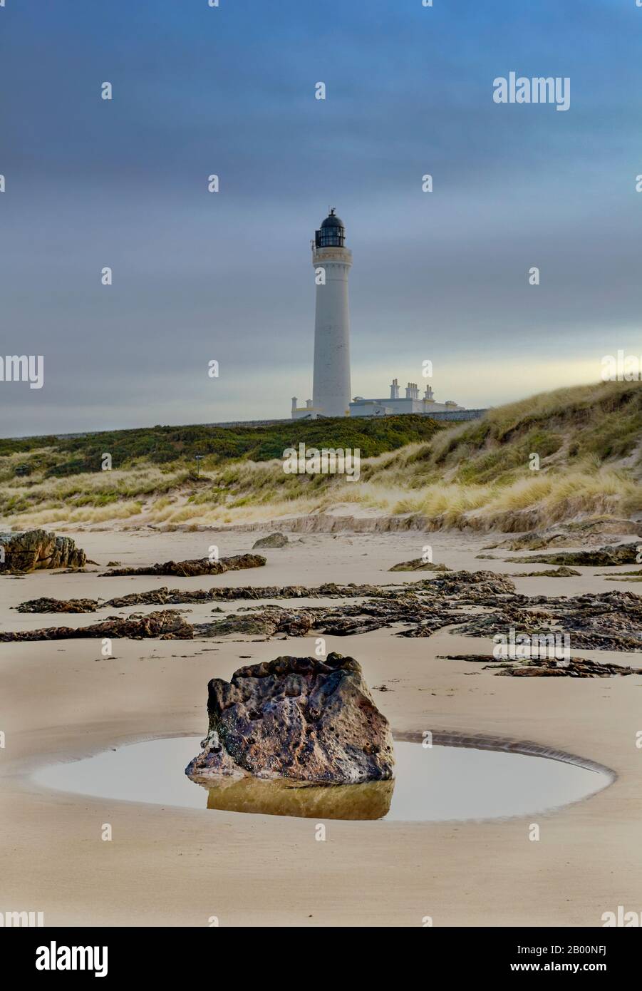 LOSSIEMOUTH MORAY FIRTH SCOTLAND A WINTER WEST BEACH ROCK AND ROCK POOL COVESEA LIGHTHOUSE ABOVE THE SANDY BEACH Stock Photo