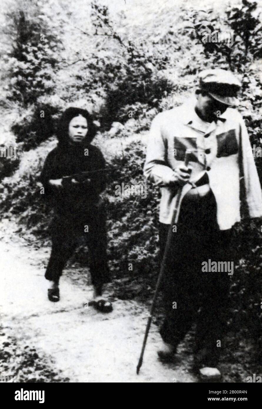 Vietnam: A female Vietnamese militia woman drives a captured Chinese PLA soldier ahead of her during the 1979 Chinese invasion of Vietnam.  A female Vietnamese militia woman drives a captured Chinese PLA soldier ahead of her during the 1979 Chinese invasion of Vietnam (the Third Indochina War). The image is strikingly (and perhaps deliberately) reminiscent of a similar photograph from the Second Indochina War showing a large American pilot being driven by a tiny Vietnamese female soldier. Stock Photo