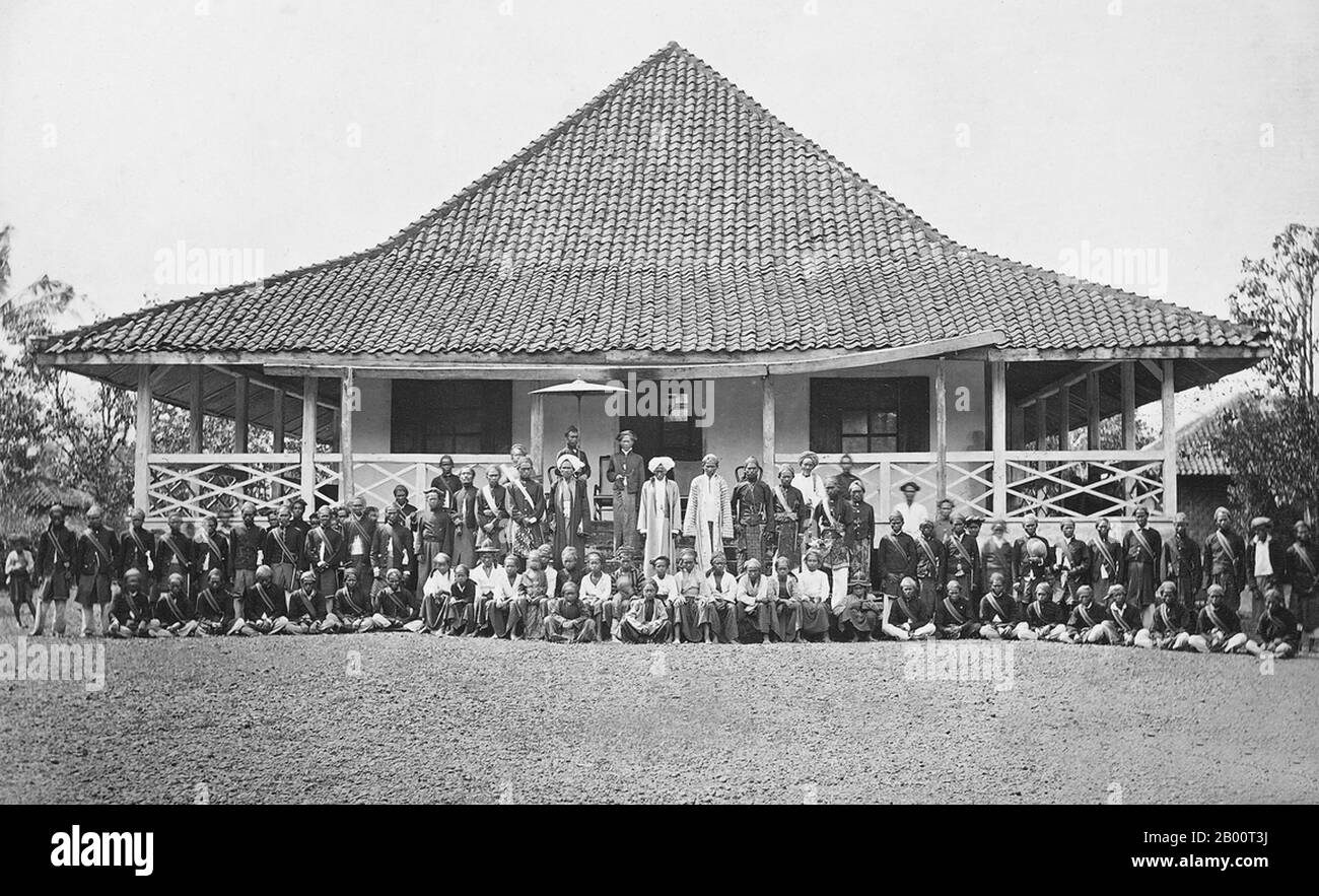 Indonesia: Wedono of Banjaran near Bandung with His Following in Front of His House, 19th century.  This photograph shows the Wedono of Banjaran (a region in present-day West Java near Bandung), in front of his house, with members of his entourage. In Dutch-administered Java, a wedono was a native regional administrator. The photograph was taken by the studio of Woodbury & Page, which was established in 1857 by the British photographers Walter Bentley Woodbury and James Page. Stock Photo