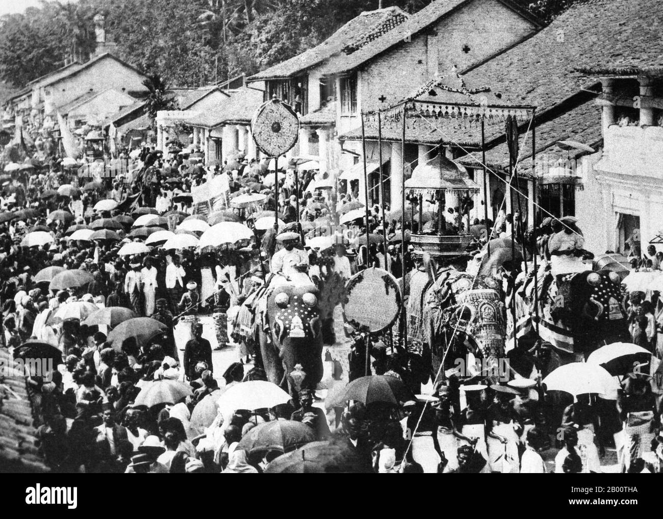Sri Lanka: Esala Perahera procession in Kandy, c. 1910.  The Esala Perahera or ‘Festival of the Tooth’ held annually in Kandy is believed to be a fusion of two separate but interconnected ‘Perahera’ (Processions), The Esala and Dalada. The Esala Perahera which is thought to date back to the 3rd century BCE, was a ritual enacted to request the gods for rainfall. The Dalada Perahera is believed to have begun when the Sacred Tooth Relic of the Buddha was brought to Sri Lanka from India during the 4th Century CE. Stock Photo
