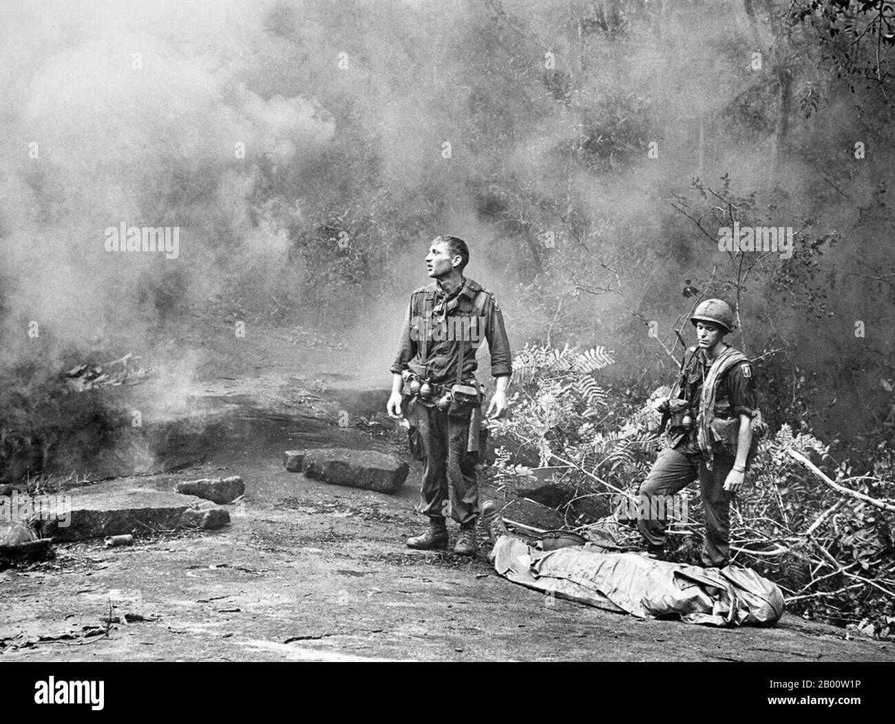 Vietnam: Weary American soldiers pause for reflection during the battle of Long Khanh, 1966.  The Second Indochina War, known in the USA as the Vietnam War, was a Cold War era military conflict that occurred in Vietnam, Laos, and Cambodia from 1 November 1955 to the fall of Saigon on 30 April 1975.   The war followed the First Indochina War and was fought between North Vietnam, supported by its communist allies, and the government of South Vietnam, supported by the US. and other anti-communist nations. Stock Photo