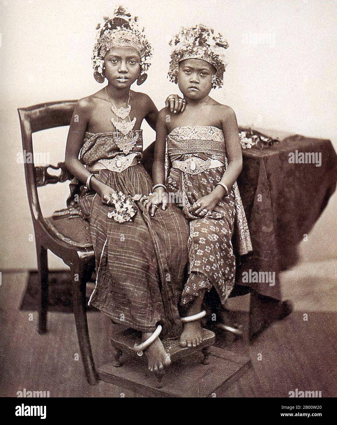 Indonesia: Two Balinese princesses in royal regalia, c. 1900.  Bali is home to most of Indonesia's small Hindu minority with some 92% of the island’s 4 million population adhering to Balinese Hinduism, while most of the remainder follow Islam.  Bali is the largest tourist destination in Indonesia, and is renowned for its highly developed arts, including traditional and modern dance, sculpture, painting, leatherwork, metalwork and music. Stock Photo