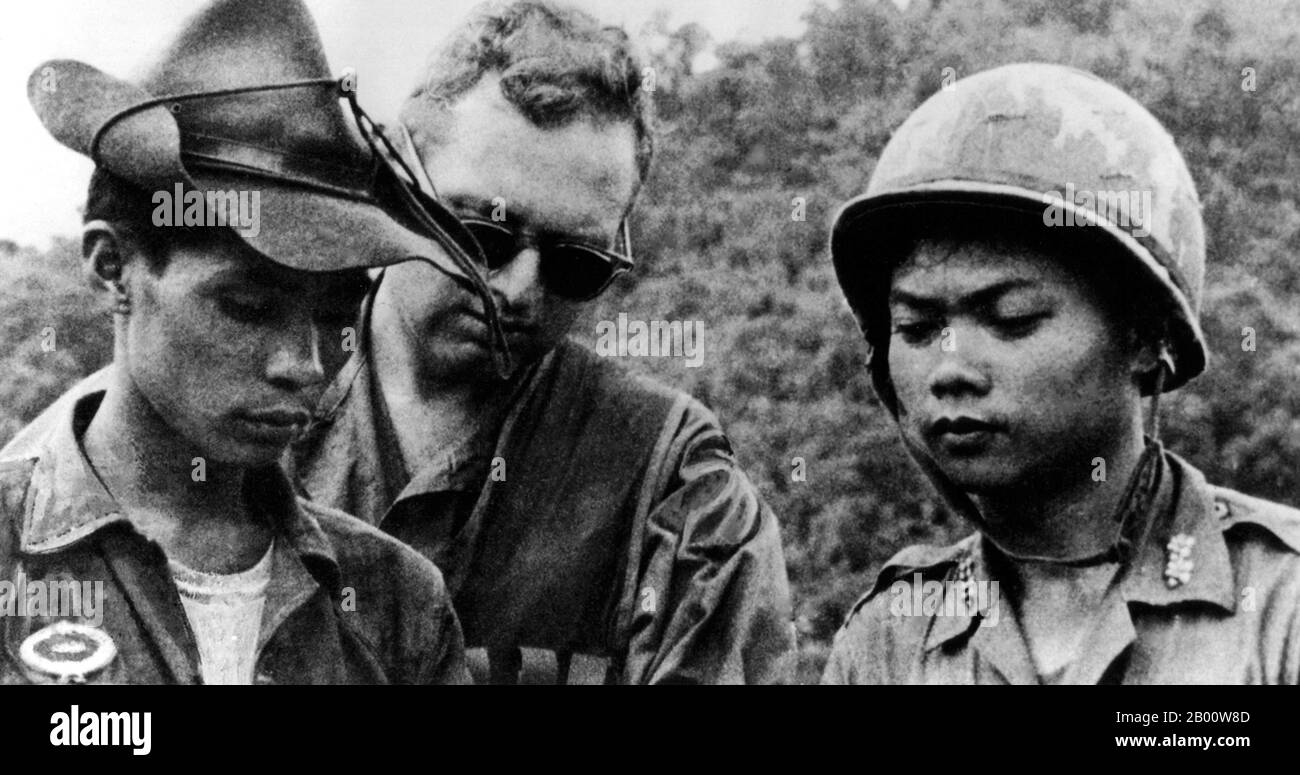 Vietnam: Army of the Republic of South Vietnam (ARVN) soldiers with an American adviser, c. 1965.  The Second Indochina War, known in America as the Vietnam War, was a Cold War era military conflict that occurred in Vietnam, Laos, and Cambodia from 1 November 1955 to the fall of Saigon on 30 April 1975. This war followed the First Indochina War and was fought between North Vietnam, supported by its communist allies, and the government of South Vietnam, supported by the U.S. and other anti-communist nations. The U.S. government viewed involvement in the war as a way to prevent a communist takeo Stock Photo