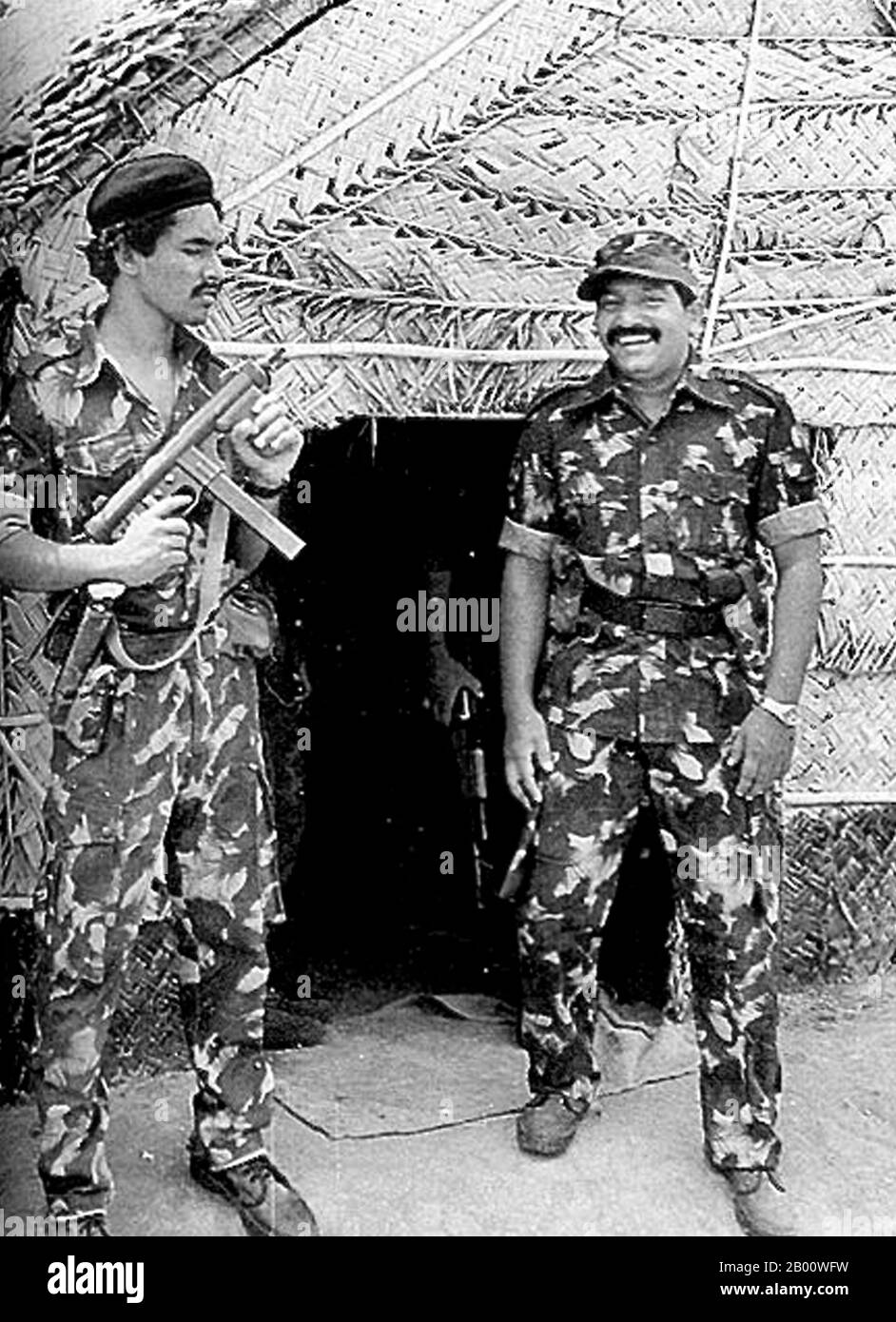 Sri Lanka: Velupillai Prabhakaran and armed bodyguard at an LTTE camp in the Jaffna Peninsula, January 1986.  Velupillai Prabhakaran ( November 26, 1954 – May 19, 2009 was the founder and leader of the Liberation Tigers of Tamil Eelam (the LTTE or the Tamil Tigers), a militant organization that sought to create an independent Tamil state in the north and east of Sri Lanka. For over 25 years, the LTTE waged a violent secessionist campaign in Sri Lanka that led to it being designated a terrorist organization by 32 countries. He was killed by government forces on May 18, 2009. Stock Photo