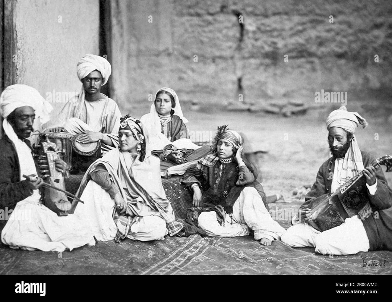 Afghanistan: Three nautch girls with musicians, taken at Kabul in Afghanistan by John Burke (1843-1900), c. 1879-1880.  The word Nautch is an anglicized version of nāc, a word found in Hindi and Urdu and several other languages of North India, derived from the Sanskrit, Nritya, via the Prakrit, Nachcha. A simple and literal translation of Nautch is 'dance' or 'dancing'.  The culture of the performing art of Nautch rose to prominence during the later period of Mughal Empire, and the East India Company Rule. Stock Photo