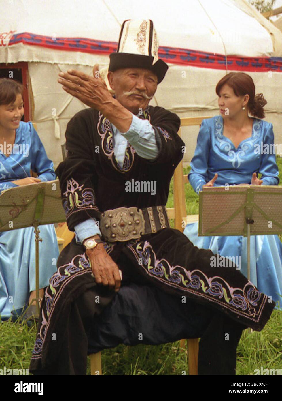 Kyrgyzstan: A Kyrgyz man dressed in traditional clothing and wearing a traditional Kalpak hat.  The central figure is a Manaschi, a traditional storyteller who has memorised the entire Manas epic legend. Public Domain image by Simon Garbutt. Stock Photo