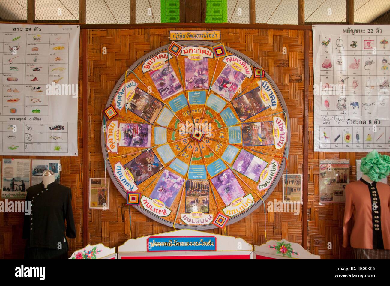 Thailand: A wheel showing the 12 month cycle of festivals and events in the Tai Dam calendar, situated at the local school, Ban Na Pa Nat Tai Dam Cultural Village, Loei Province.  The Tai Dam or Black Tai are an ethnic group found in parts of Laos, Vietnam, China, and Thailand.  Tai Dam speakers in China are classified as part of the Dai nationality along with almost all the other Tai peoples. But in Vietnam they are given their own nationality (with the White Tai) where they are classified as the Thái nationality (meaning Tai people). Stock Photo