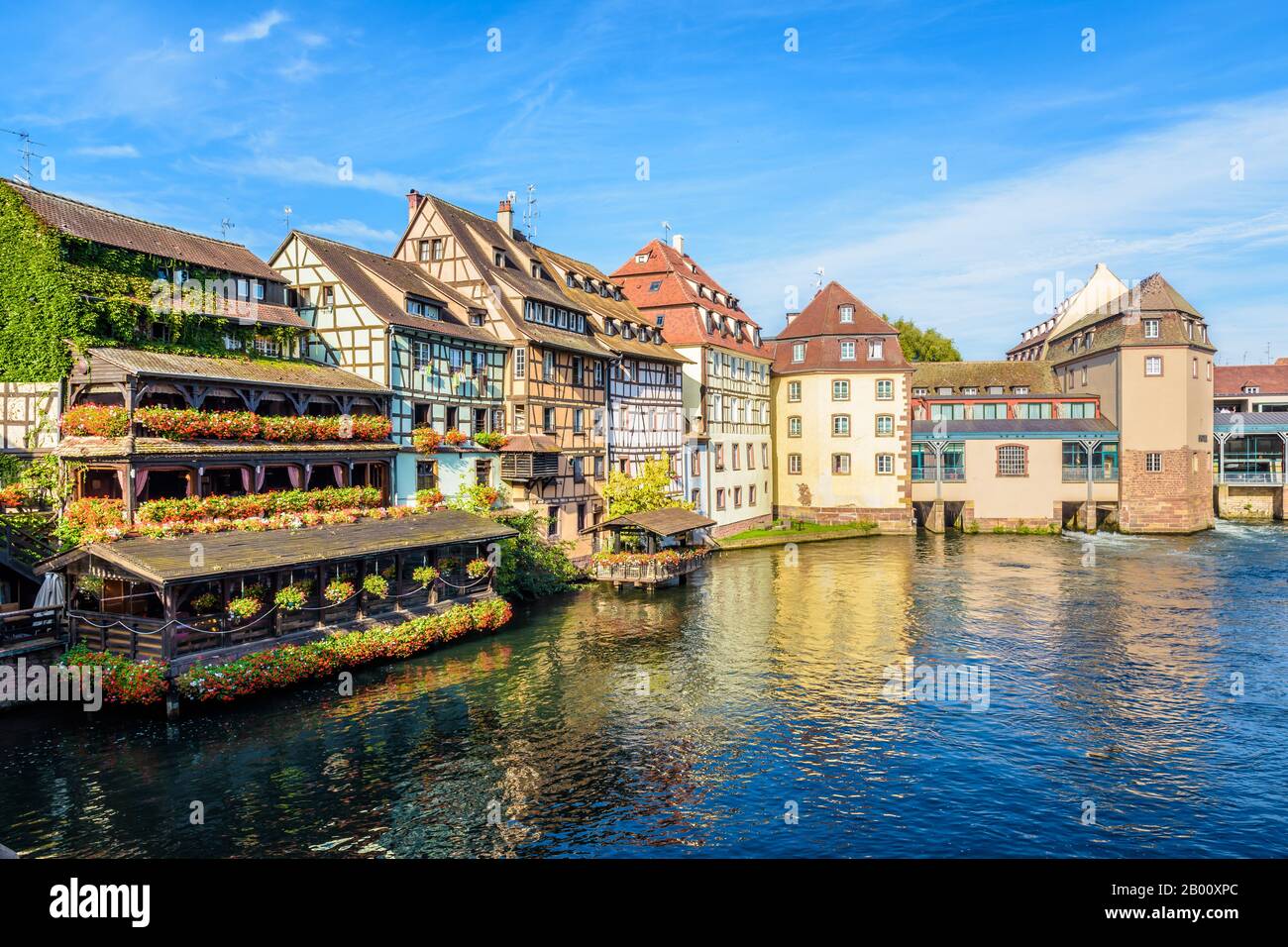 Half-timbered buildings and former water mills lining the river Ill in the Petite France quarter in Strasbourg, France, on a sunny morning. Stock Photo