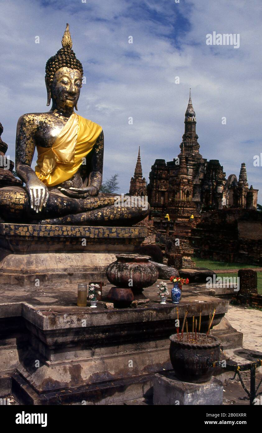 Thailand: Buddha, Wat Mahathat, Sukhothai Historical Park.  Wat Mahathat was founded in the 13th century by King Intharathit (c. 1240-70) and rebuilt in the 14th century. It was the spiritual heart of the Sukhothai Kingdom.  Sukhothai, which literally means 'Dawn of Happiness', was the capital of the Sukhothai Kingdom and was founded in 1238. It was the capital of the Thai Empire for approximately 140 years. Stock Photo