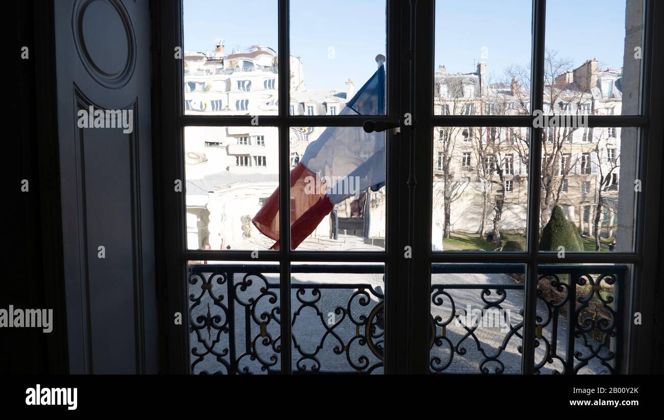 French flag blowing in the wind, view from the d'Orsay Museum, Paris, France, buildings distorted by window glass. Stock Photo