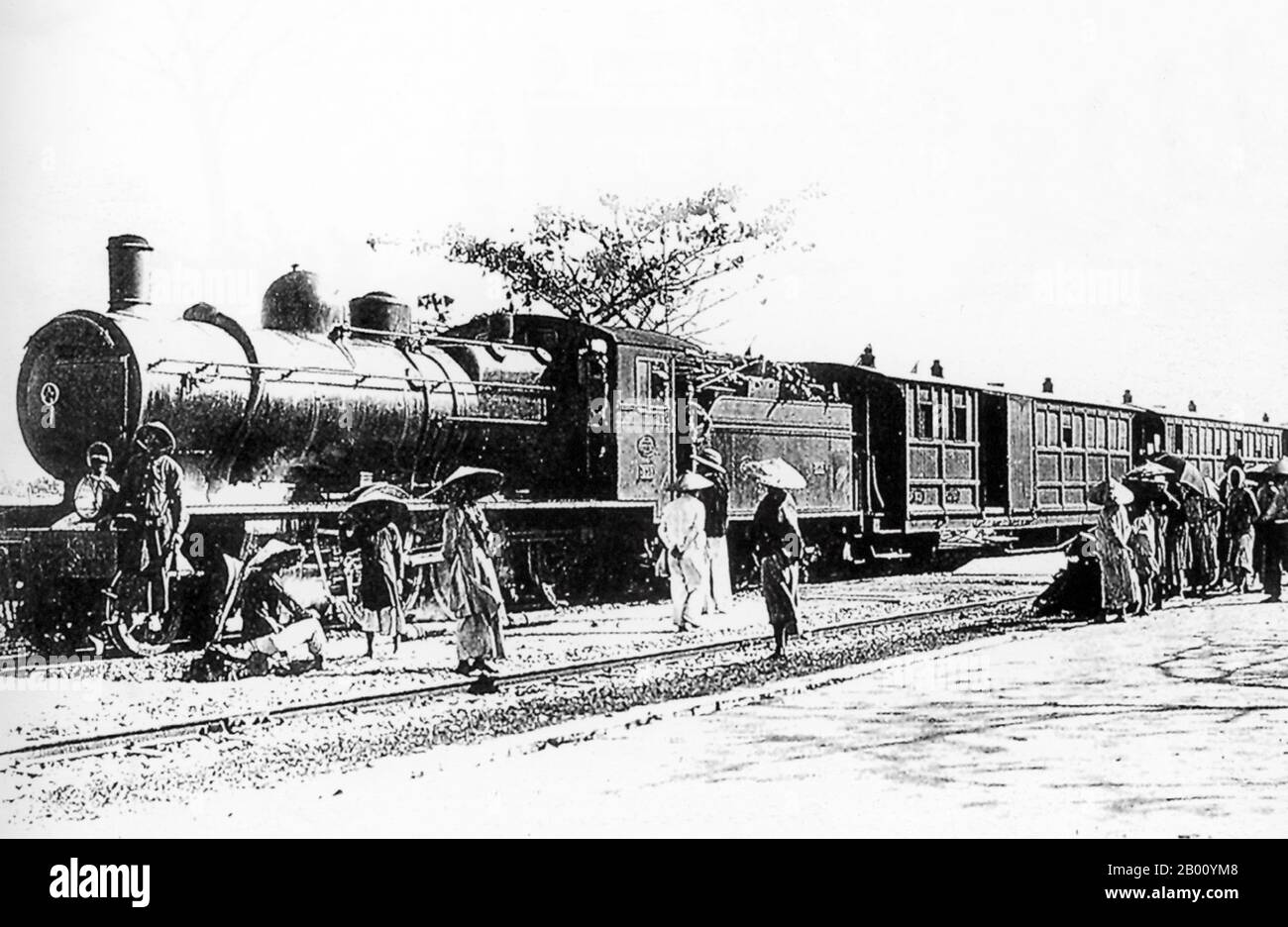 Vietnam: A steam locomotive on the Danang to Hue railway line (early 20th century).  The Vietnam North-South Railway, runs 1,726 km (1,080 miles) from Hanoi to Saigon (Ho Chi Minh City) along the Vietnamese coast on a 1-m gauge track. The railway was constructed by French colonists as part of a railway network in Indochina. It was officially inaugurated on October 2, 1936. Nowadays known as the Reunification Express, the railway is  renowned as the slowest train service in the world. Stock Photo