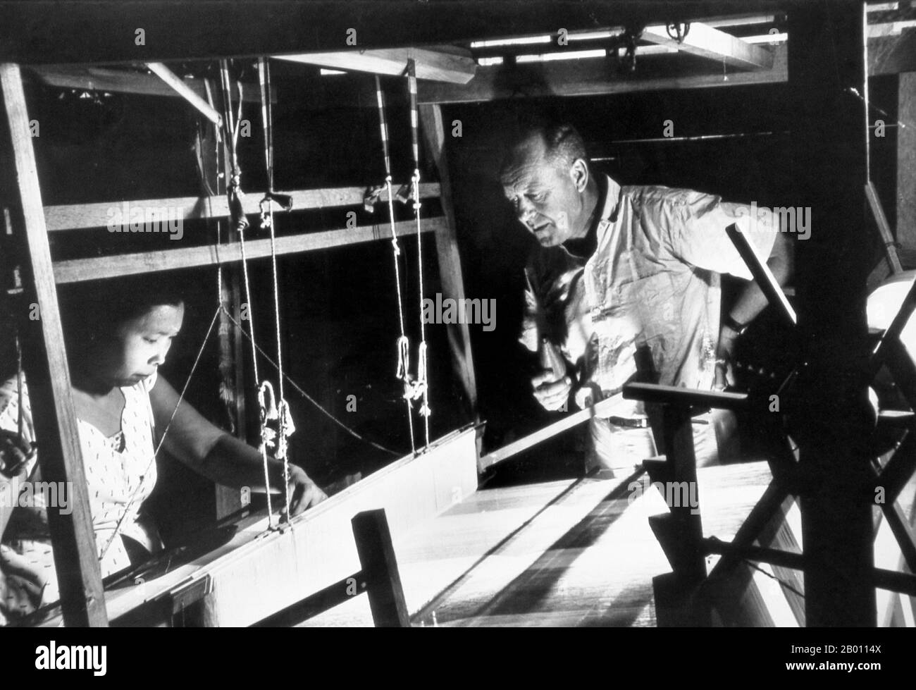 Thailand: Jim Thompson watching a Cham silk weaver, Bangkok, early 1960s.  James (Jim) Harrison Wilson Thompson (born March 21, 1906 in Greenville, Delaware - unknown) was an American businessman who helped revitalize the Thai silk industry in the 1950s and 1960s. A former U.S. military intelligence officer, Thompson mysteriously disappeared from Malaysia's Cameron Highlands while going for a walk on Easter Sunday, March 26, 1967. Stock Photo