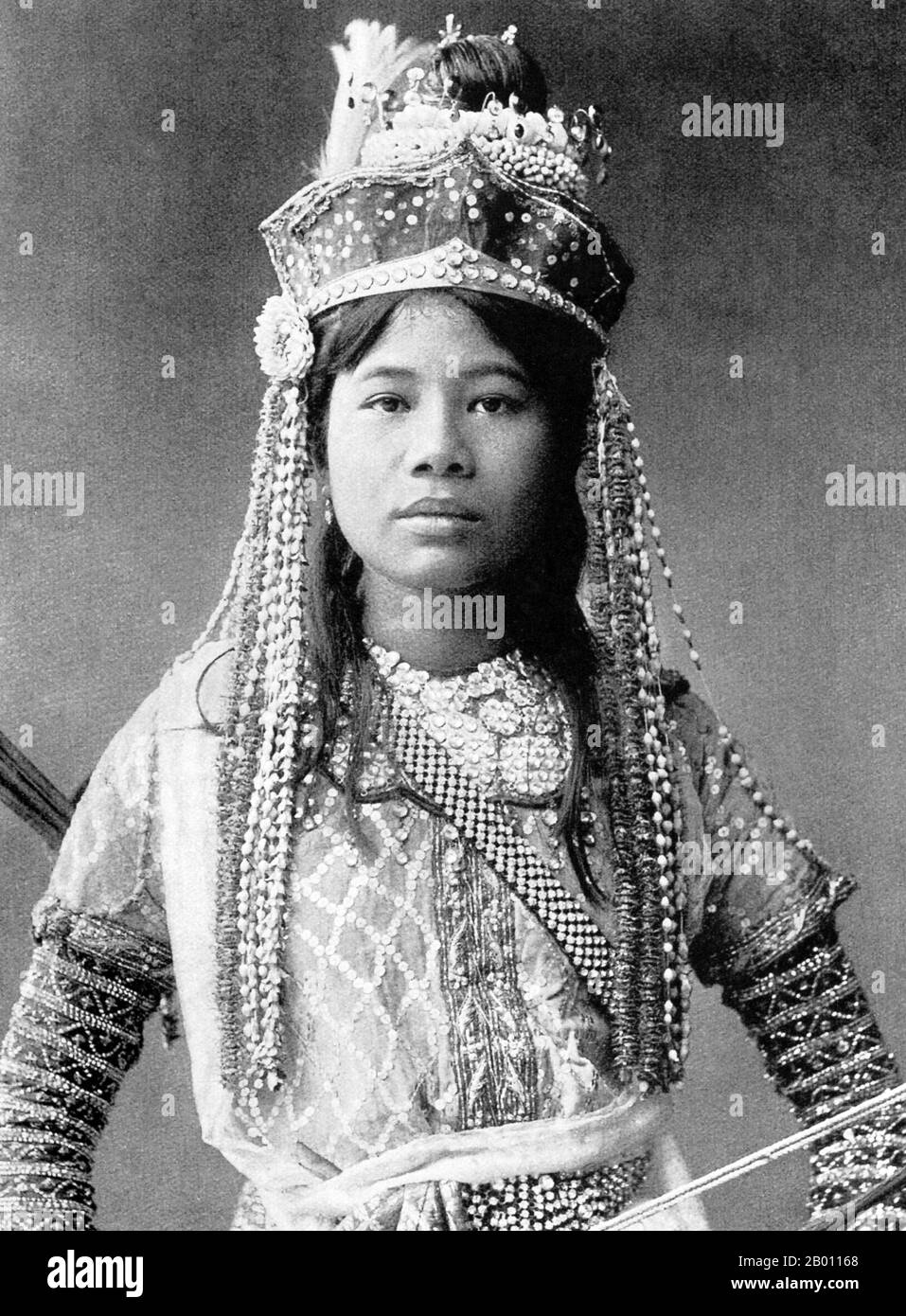 Thailand: A leading actor in a Siamese play poses in his theatre dress, c. 1900.  The Siamese were avid theatre-goers at the turn of the 20th century. Mime, dance, plays and shadow puppetry were all very popular. Many of the stage plays involved dancers, mostly female, who adorned themselves in jewellery and exhibited lithe movements portraying beauty and flexibility, especially in bending the fingers back. The most common plays were called ‘khon’, which essentially feature scenes from the ‘Ramakien’, the Thai version of the Hindu epic ‘The Ramayana’. Stock Photo
