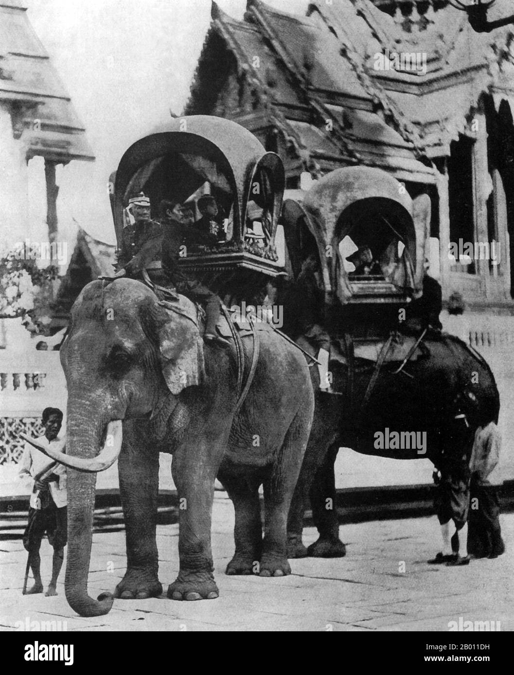 Thailand: Elephants caparisoned with howdahs carry the young princes in the courtyard of the Grand Palace in Bangkok, late 19th century.   In the 19th century, the Asian Elephant held a prominent position in Siam, although they were hunted regularly north of Ayutthaya and the Lao States (present day, Chiang Mai province and Isan). Not only were elephants used as beasts of burden in agriculture and for hauling timber, but they were active in war leading cavalry charges against the enemy. Elephants were frequently employed in the Siamese-Burmese wars of the Middle Ages. Stock Photo