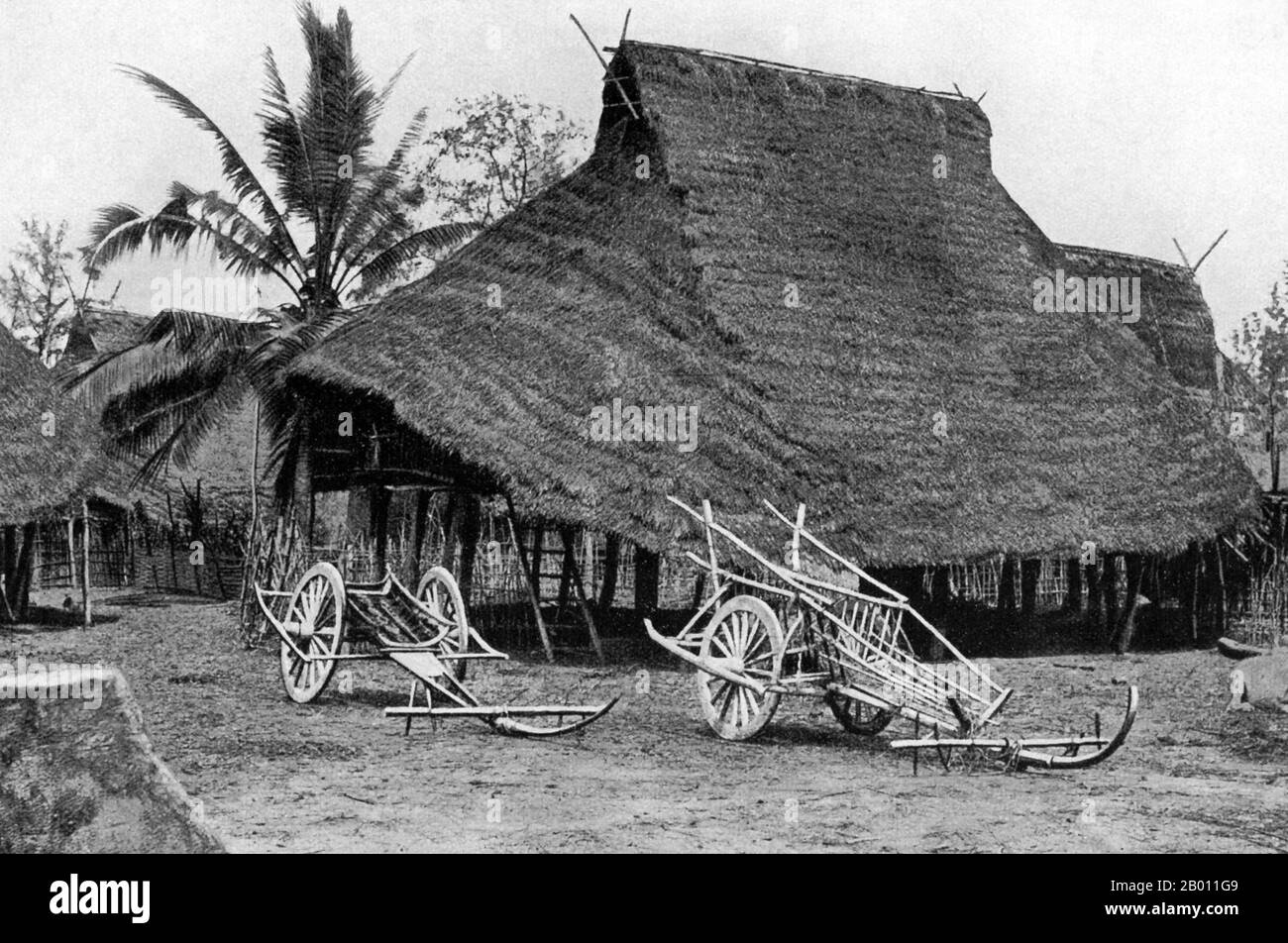 Thailand: Ox carts lie in front of a traditional thatched wooden house on stilts in rural Phitsanulok, central Thailand, c. 1900.  Phitsanulok is an ancient city in the lower plains of northern Thailand. It was capital of the Ayutthaya kingdom for 25 years from 1463 after a series of Burmese invasions. Although Phitsanulok is not located far to the north, the people of the region were known to the central Siamese as Lao at the turn of the 20th century. Stock Photo
