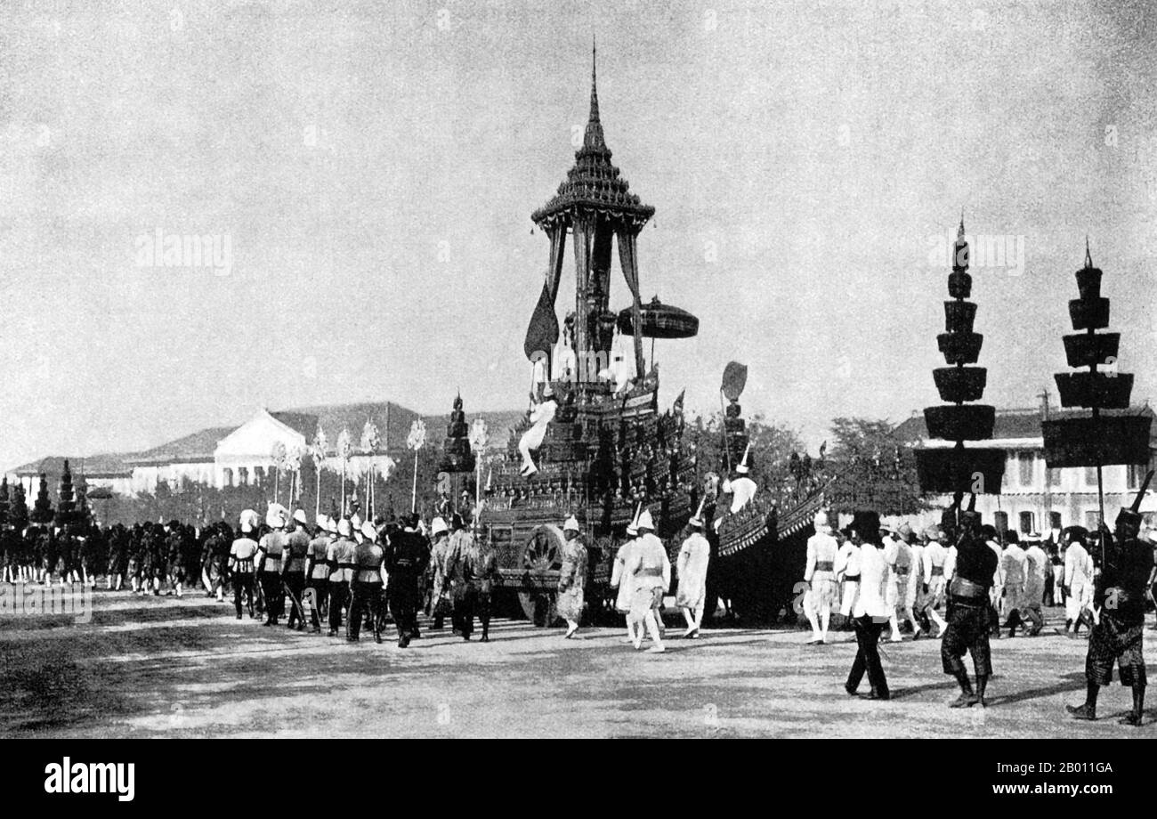 Thailand: A funeral possession accompanies the carriage carrying the remains of King Chulalongkorn, 1911.  Elaborate pavilions and Buddhist temples are traditionally constructed especially for royal funerals in Siam. The body of the deceased was embalmed and preserved while the cremation site was built. Funereal rites and a period of mourning could take months or even a year before the funeral took place. The embalmed body was then placed in a kneeling position in a gold urn on a high bier inside an ornate edifice to be cremated. Stock Photo