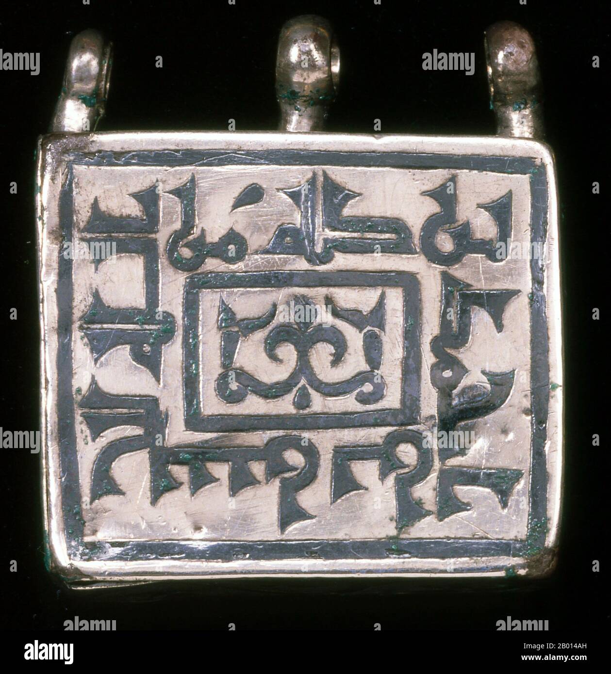 Iran: A ta'wiz or amulet case in silver and nielloware, used for carrying a short verse from the Qur'an for protection and good luck. The Arabic inscription on the face is the shahada or Muslim profession of faith in Kufic script, 10th-11th century.  Ta'wiz or Tawiz are lockets usually containing verses from the Quran or other Islamic prayers and symbols. As a general rule it is worn with the belief that it will repel any evil intended for the wearer and will also bring him luck. As such it is intended to be an amulet. The word Ta'wiz is also used to refer to other amulets used in Islam. Stock Photo