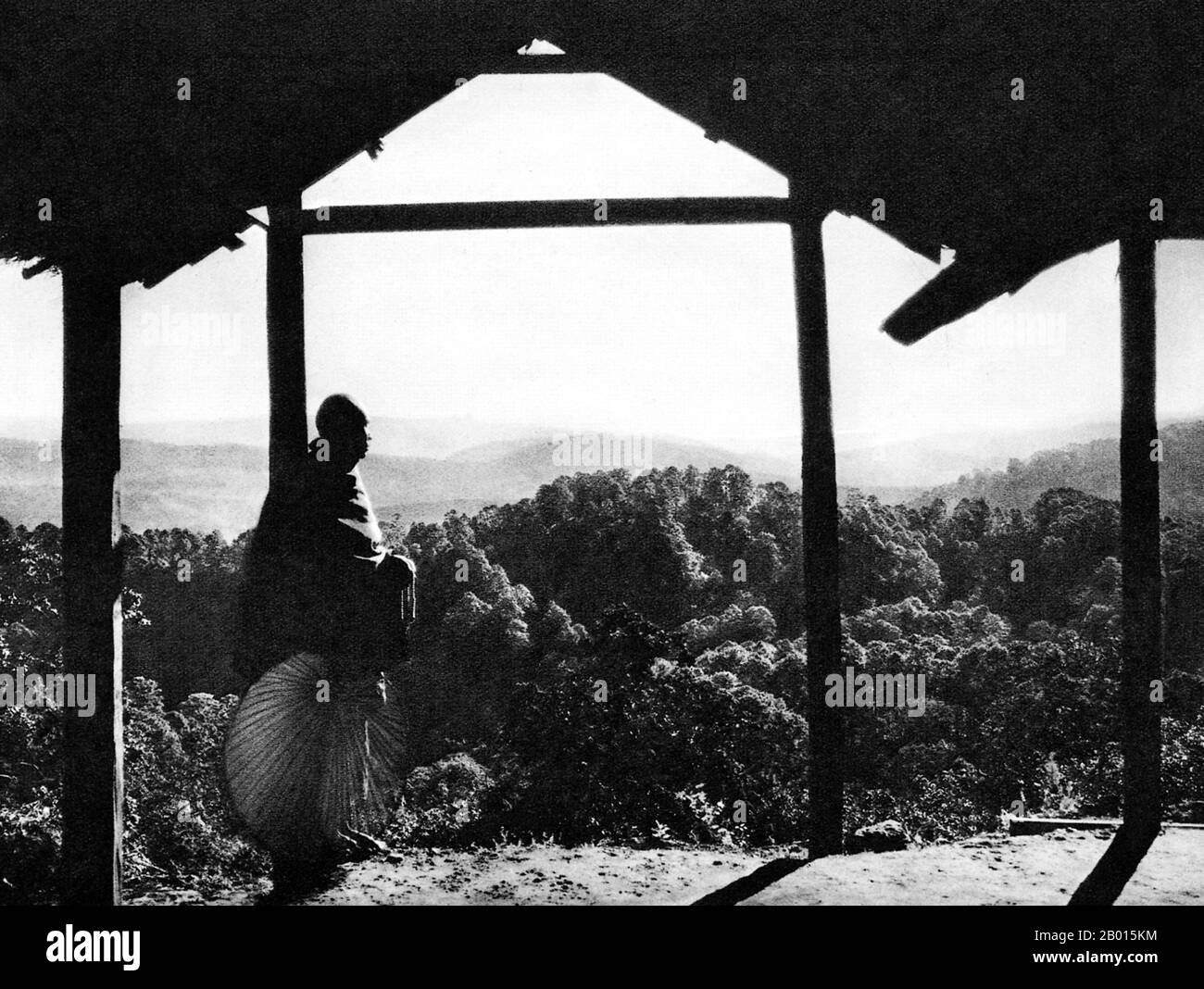 Burma/Myanmar: A Buddhist monk looks out over the mountains in Kalaw, Shan State, c. 1920s.  Kalaw is a hill town in southwestern Shan State, northern Burma, that was a popular retreat for British officers during colonial rule.  The British conquest of Burma began in 1824 in response to a Burmese attempt to invade India. By 1886, and after two further wars, Britain had incorporated the entire country into the British Raj.  To stimulate trade and facilitate changes, the British brought in Indians and Chinese, who quickly displaced the Burmese in urban areas. Stock Photo