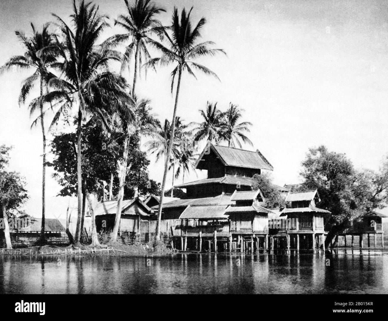 Burma/Myanmar: A Buddhist monastery overlooks the Balu River near Mong Pai in southern Shan State, c. 1920s.   The British conquest of Burma began in 1824 in response to a Burmese attempt to invade India. By 1886, and after two further wars, Britain had incorporated the entire country into the British Raj.  To stimulate trade and facilitate changes, the British brought in Indians and Chinese, who quickly displaced the Burmese in urban areas. To this day Rangoon and Mandalay have large ethnic Indian populations. Railways and schools were built, as well as a large number of prisons. Stock Photo