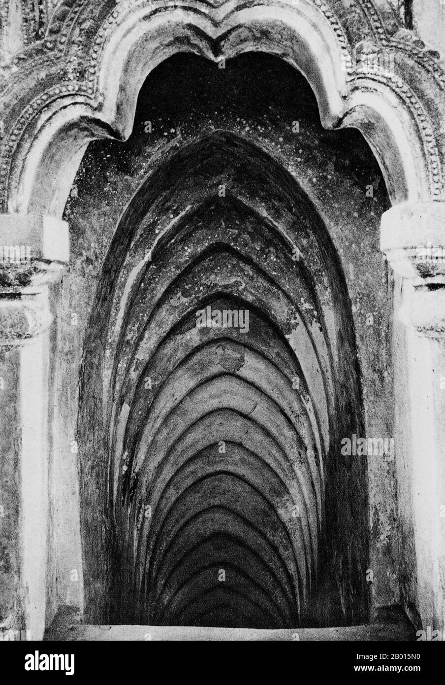 Burma/Myanmar: A staircase inside Thatbyinnyu Pagoda in Bagan, Upper Burma, c. 1920s.  The 61 m-high Thatbyinnyu temple was built as a Buddhist monastery (vihara) in 1144 during the reign of King Alaungsithu. It is adjacent to Ananda Temple. Thatbyinnyu Temple is shaped like a cross, but is not symmetrical. The temple has two primary storeys, with the seated Buddha image located on the second storey.  The ruins of Bagan (also spelled Pagan) cover an area of 16 square miles (41 km2). The majority of its buildings were built between the 11th and 13th centuries, when Bagan was capital. Stock Photo