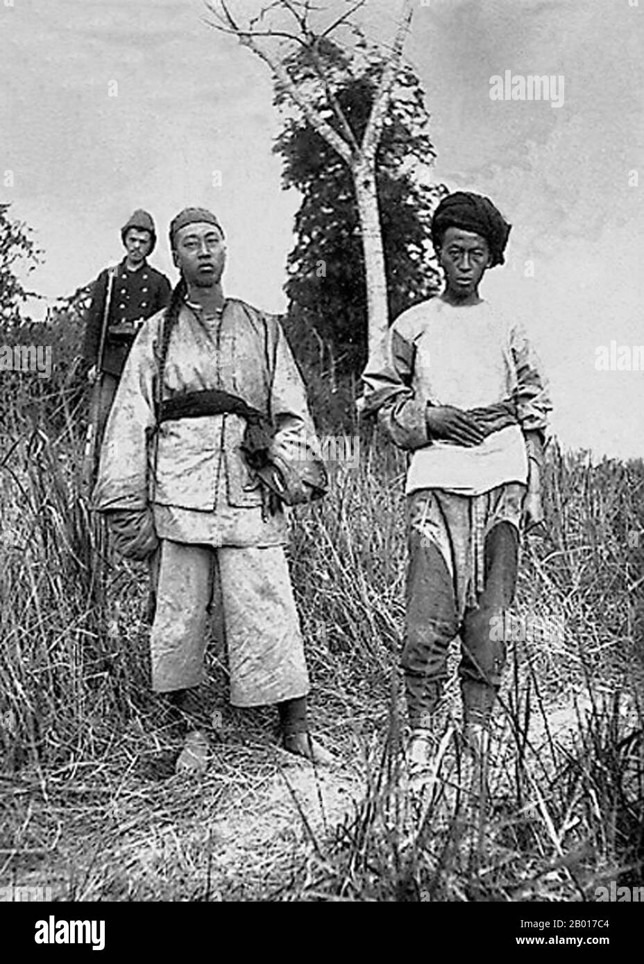 Vietnam: Two Black Flag militia and a French rifleman, Tuyen Quang, Tonkin, 1885.  The Black Flag Army (Chinese: Hēiqí Jūn; Vietnamese: Quân cờ đen) was a splinter remnant of a bandit group recruited largely from soldiers of ethnic Zhuang background, who crossed the border from Guangxi province of China into Upper Tonkin, in the Empire of Annam (Vietnam) in 1865. They became known mainly for their fights against French forces in cooperation with both Vietnamese and Chinese authorities. The Black Flag Army is so named because of their leader Liu Yongfu's preference for using black command flags Stock Photo