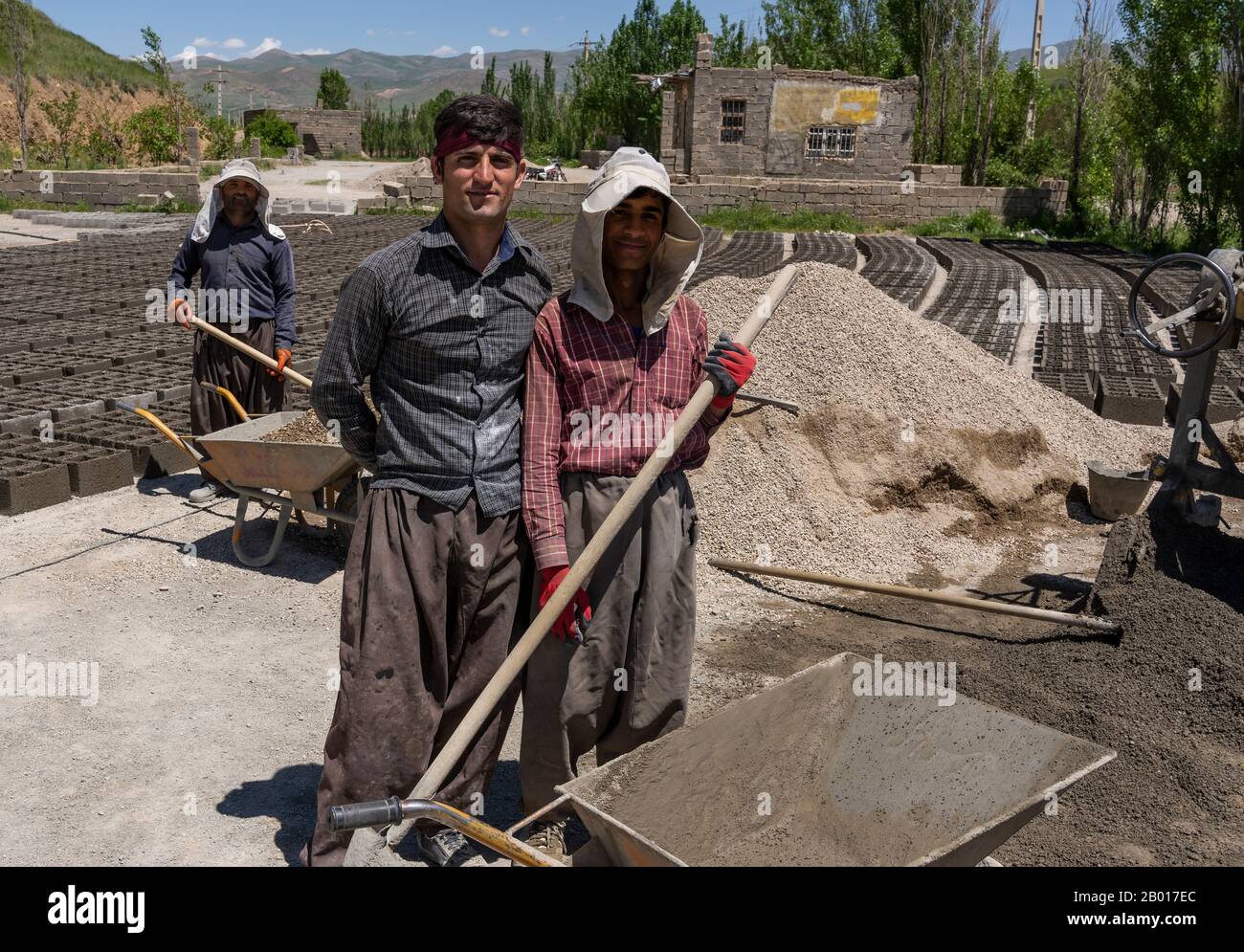 Shahin Dezh, Iran - May 15, 2019: Three workers allong the road making bricks, Iran. Stock Photo