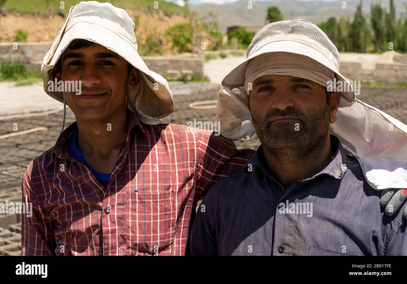 Shahin Dezh, Iran - May 15, 2019: Two workers making bricks allong the street, Iran. Stock Photo