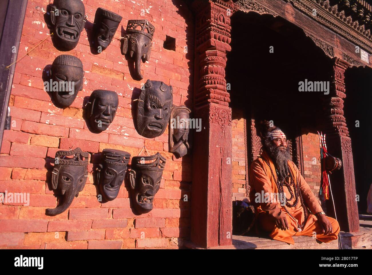 Nepal: Sadhu (Holy Man) in Durbar Square, Kathmandu.  They are known, variously, as sadhus (saints, or 'good ones'), yogis (ascetic practitioners), fakirs (ascetic seeker after the Truth) and sannyasins (wandering mendicants and ascetics). They are the ascetic – and often eccentric – practitioners of an austere form of Hinduism. Sworn to cast off earthly desires, some choose to live as anchorites in the wilderness. Others are of a less retiring disposition, especially in the towns and temples of Nepal's Kathmandu Valley. Stock Photo