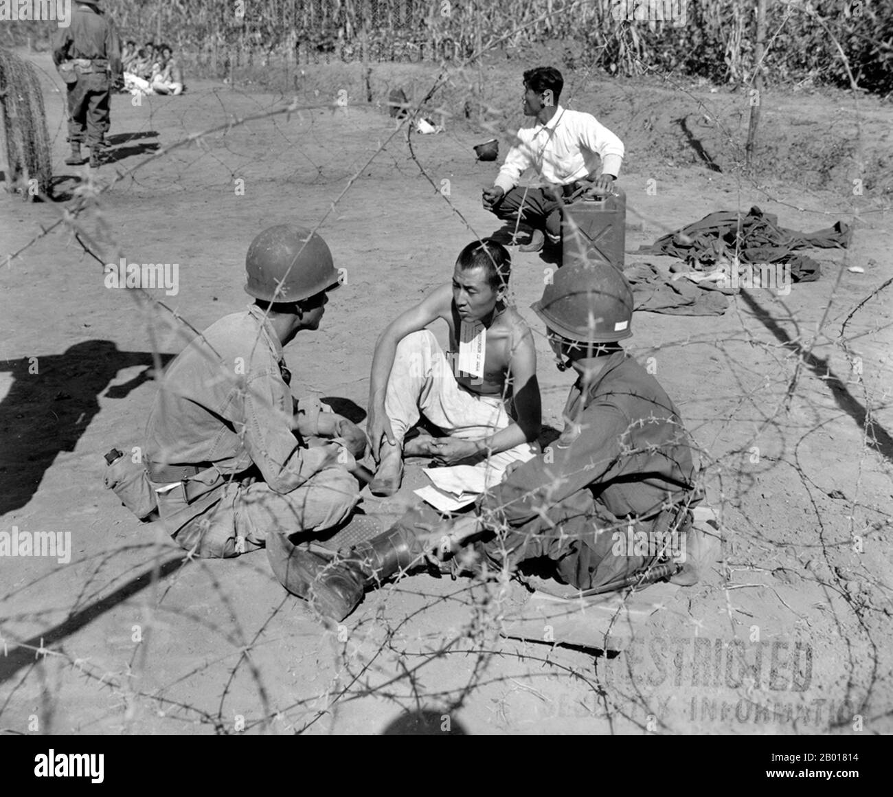 Korea: During the Korean War (25 June 1950 - armistice signed 27 July 1953) an interrogation team of the US 7th Infantry Division question a POW, Anvang-Ni, 20 September, 1950.  The Korean War was a military conflict between the Republic of Korea, supported by the United Nations, and North Korea, supported by the People's Republic of China (PRC), with military material aid from the Soviet Union. The war was a result of the physical division of Korea by an agreement of the victorious Allies at the conclusion of the Pacific War at the end of World War II. Stock Photo