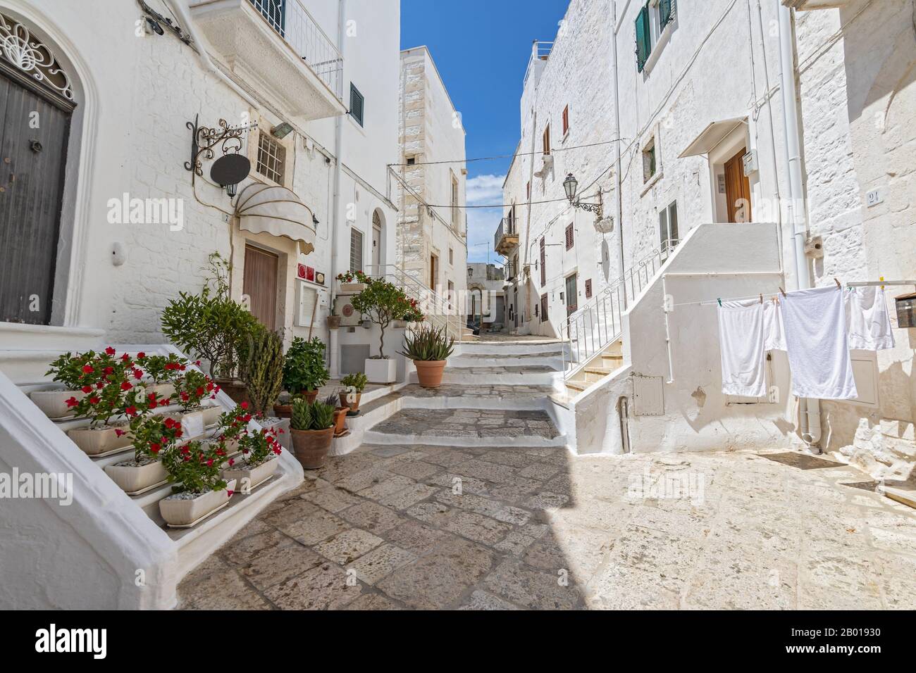 Picturesque narrow street with traditional white washed houses in the old historic center in Ostuni, Puglia, Italy Stock Photo - Alamy