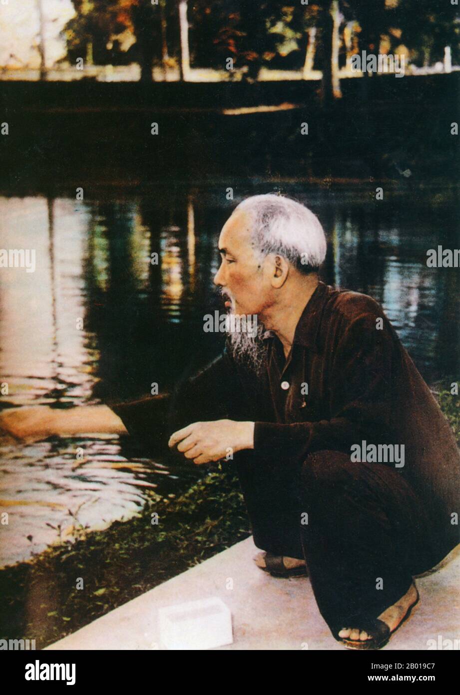 Vietnam: President Ho Chi Minh (19 May 1890 - 3 September 1969) feeding fish in the grounds of the Presidential Palace, Hanoi, c. 1960.  Hồ Chí Minh, born Nguyễn Sinh Cung and also known as Nguyễn Ái Quốc was a Vietnamese Communist revolutionary leader who was prime minister (1946-1955) and president (1945-1969) of the Democratic Republic of Vietnam (North Vietnam). He formed the Democratic Republic of Vietnam and led the Viet Cong during the Vietnam War until his death. Stock Photo