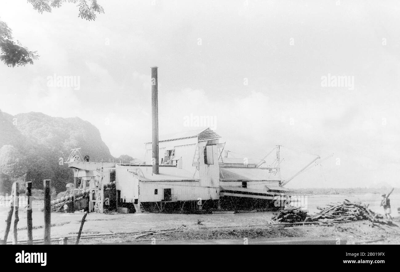 Thailand: A tin dredger at work in Phang Nga Bay, 1952.  Phuket, formerly known as Talang and, in Western sources, Junk Ceylon (a corruption of the Malay Tanjung Salang, i.e. 'Cape Salang'), is one of the southern provinces (changwat) of Thailand. Neighbouring provinces are (from north clockwise) Phang Nga and Krabi, but as Phuket is an island there are no land boundaries.  Phuket, which is approximately the size of Singapore, is Thailand’s largest island. The island is connected to mainland Thailand by two bridges. It is situated off the west coast of Thailand in the Andaman Sea. Stock Photo