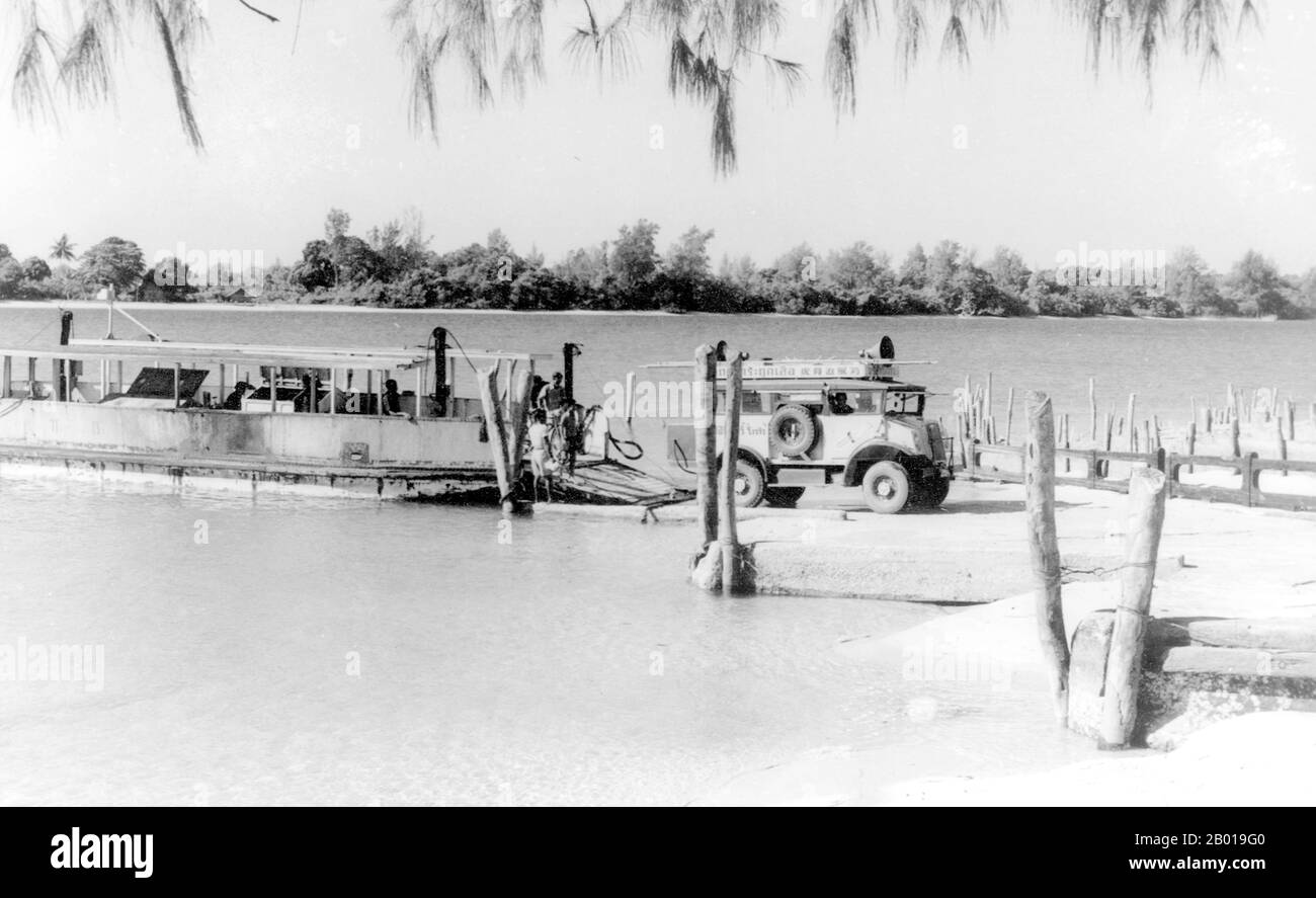 Thailand: A ferry brings cars from the mainland to northern Phuket, 1952.  Phuket, formerly known as Talang and, in Western sources, Junk Ceylon (a corruption of the Malay Tanjung Salang, i.e. 'Cape Salang'), is one of the southern provinces (changwat) of Thailand. Neighbouring provinces are (from north clockwise) Phang Nga and Krabi, but as Phuket is an island there are no land boundaries.  Phuket, which is approximately the size of Singapore, is Thailand’s largest island. The island is connected to mainland Thailand by two bridges. It is situated off the west coast in the Andaman Sea. Stock Photo