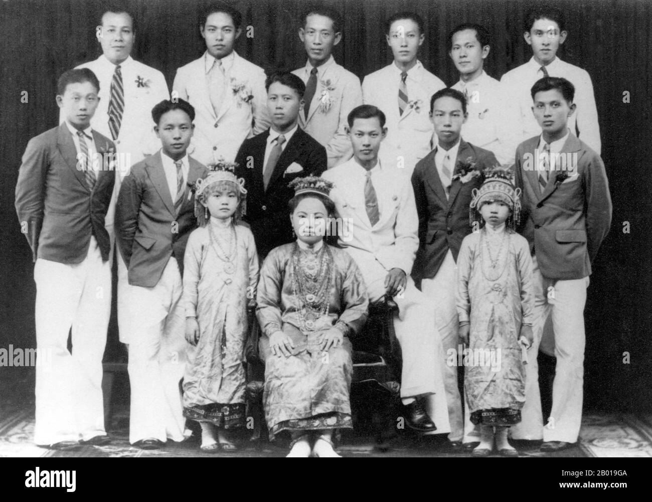 Thailand: A group of prosperous citizens of Phuket in 1942. The dress of the woman and two small girls indicate that they are ethnic Chinese 'Phuket Babas'.  Phuket, formerly known as Talang and, in Western sources, Junk Ceylon (a corruption of the Malay Tanjung Salang, i.e. 'Cape Salang'), is one of the southern provinces (changwat) of Thailand. Neighbouring provinces are (from north clockwise) Phang Nga and Krabi, but as Phuket is an island there are no land boundaries. Phuket, which is approximately the size of Singapore, is Thailand’s largest island. Stock Photo