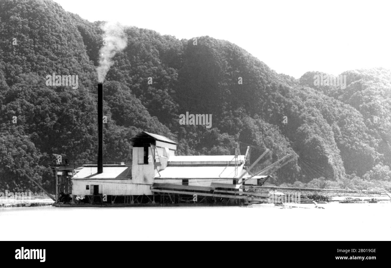 Thailand: A tin dredger operating in the waters of Phang Nga Bay, 1954.  Phuket, formerly known as Talang and, in Western sources, Junk Ceylon (a corruption of the Malay Tanjung Salang, i.e. 'Cape Salang'), is one of the southern provinces (changwat) of Thailand. Neighbouring provinces are (from north clockwise) Phang Nga and Krabi, but as Phuket is an island there are no land boundaries.  Phuket, which is approximately the size of Singapore, is Thailand’s largest island. The island is connected to mainland Thailand by two bridges. It is situated off the west coast in the Andaman Sea. Stock Photo
