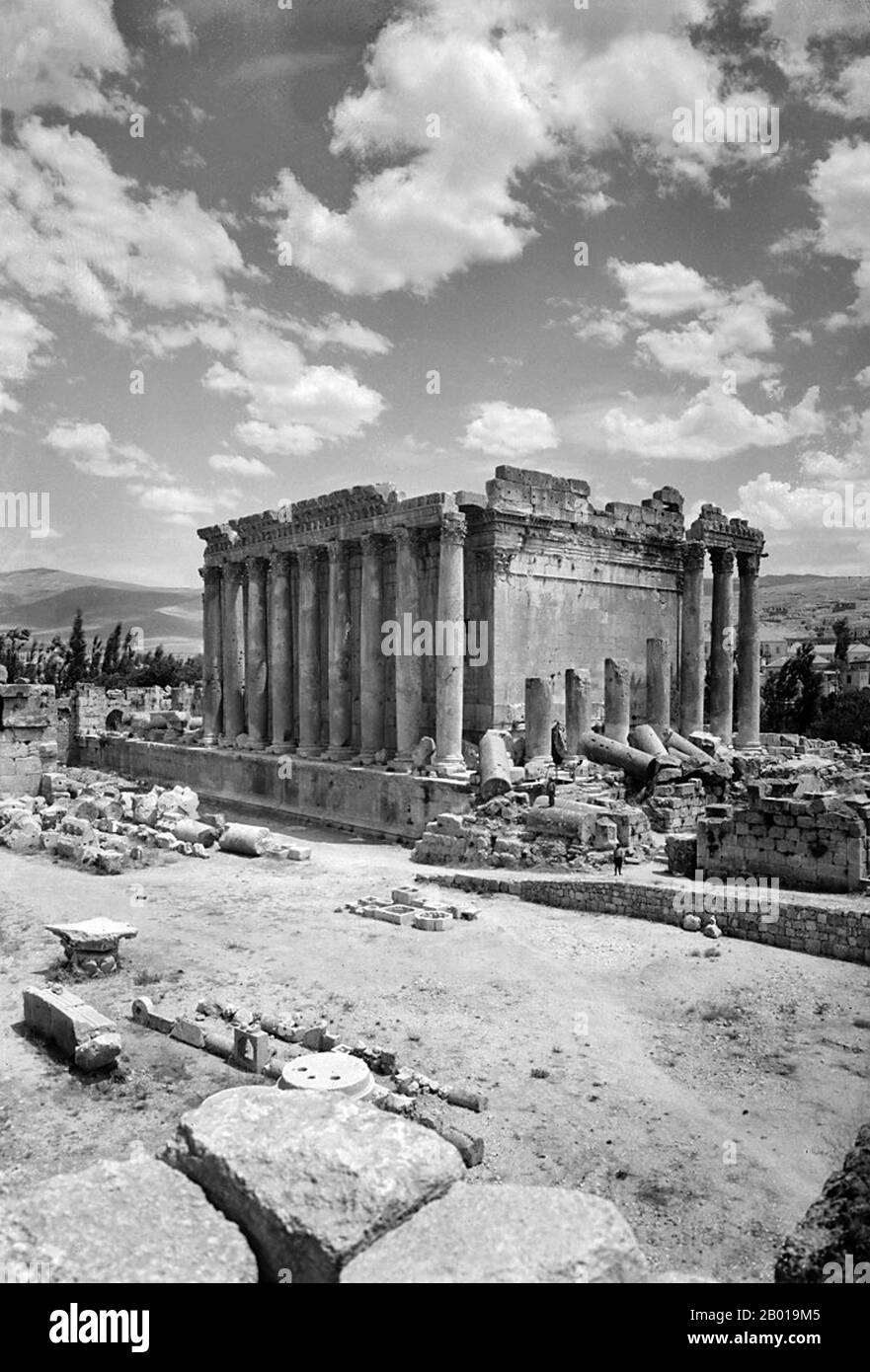Lebanon: The Temple of Bacchus at Baalbek seen from the northwest, c. 1900.  The Temple of Bacchus was one of the three main temples at a large complex in Classical Antiquity, at Baalbek in Lebanon. The temple was dedicated to Bacchus (also known as Dionysus), the Roman god of wine, but was traditionally referred to by Neoclassical visitors as the 'Temple of the Sun'. It is considered one of the best preserved Roman temples in the world. It is larger than the Parthenon in Greece, though much less famous. The temple was commissioned by Roman Emperor Antoninus Pius in 150 CE. Stock Photo