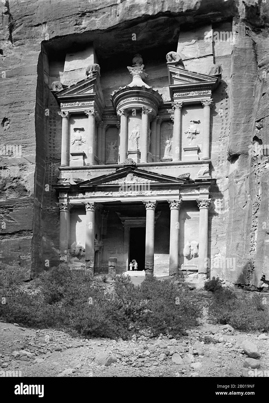 Jordan: Al Khazneh ('The Treasury') at Petra, c. 1898-1914.  Petra (Al-Batrā) is a historical and archaeological city in the Jordanian governorate of Ma'an that is known for its rock cut architecture and water conduits system. Established sometime around the 6th century BC as the capital city of the Nabataeans, it is a symbol of Jordan as well as its most visited tourism attraction. It lies on the slope of Mount Hor in a basin among the mountains which form the eastern flank of Arabah (Wadi Araba), the large valley running from the Dead Sea to the Gulf of Aqaba. Stock Photo