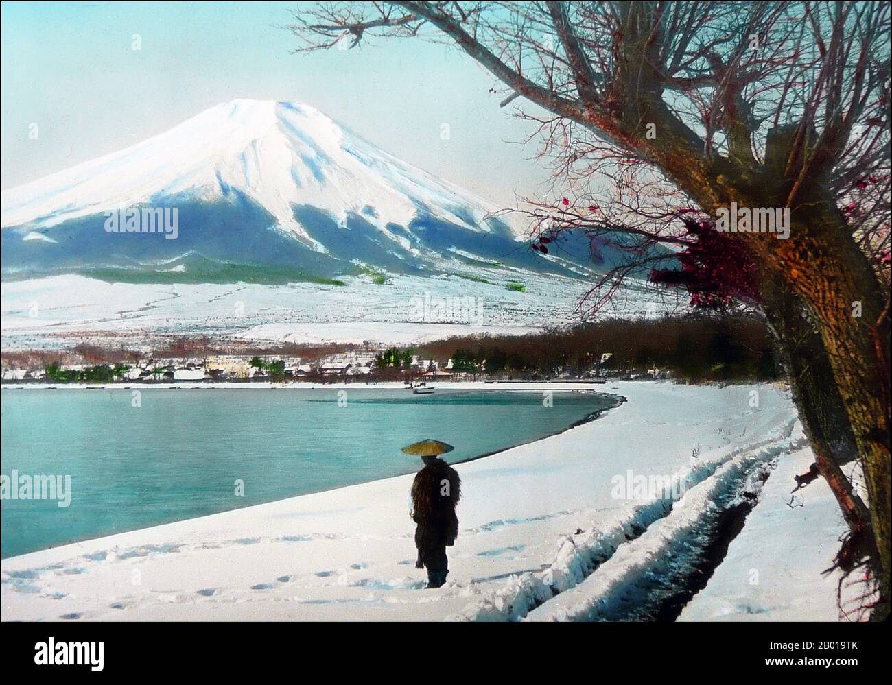 Japan: Mount Fuji from the snowy shore of Lake Yamanaka, Yamanashi Prefecture. Photo by T. Enami (1859-1929), c. 1910.  T. Enami (Enami Nobukuni) was the trade name of a celebrated Meiji period photographer. The T. of his trade name is thought to have stood for Toshi, though he never spelled it out on any personal or business document.  Born in Edo (now Tokyo) during the Bakumatsu era, Enami was first a student of, and then an assistant to the well known photographer and collotypist, Ogawa Kazumasa. Enami relocated to Yokohama, and opened a studio on Benten-dōri (Benten Street) in 1892. Stock Photo