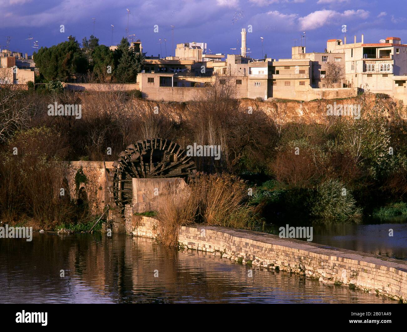 Syria: A 12th-13th century noria or giant waterwheel on the banks of the Orontes River, Hama.  A noria is a machine for lifting water into a small aqueduct for the purpose of irrigation.  Hama is the location of the historical city of Hamath. In 1982 it was the scene of the worst massacre in modern Arab history. President Hafaz al-Assad ordered his brother Rifaat al-Assad to quell a Sunni Islamist revolt in the city. An estimated 25,000 to 30,000 people were massacred. Stock Photo