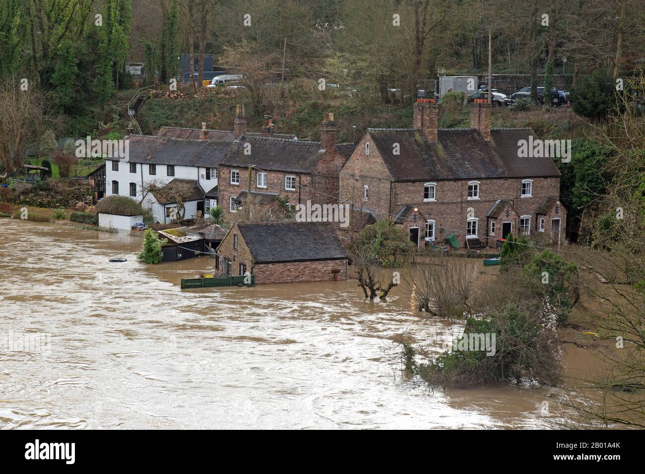 18th February 2020. The River Severn flooding in Ironbridge, Shropshire, England. A temporary flood barrier struggles to hold back the River, which has reached its highest point for 20 years, threatening homes and businesses along the River banks of the Ironbridge Gorge. The Ironbridge Gorge is a World Heritage Site. Stock Photo