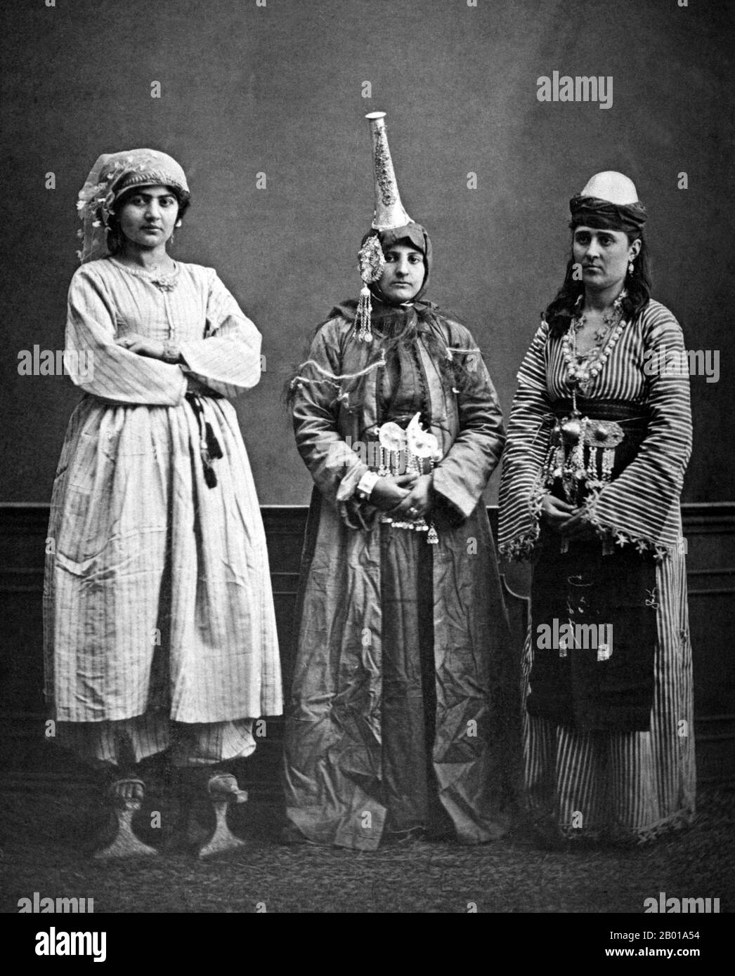 Syria: Three Syrian women, left to right - urban Arab, Druze, rural Arab. The druze woman is wearing a tantour headdress. Photo by Pascal Sebah (1823 - 25 June 1886), Damascus, 1873.  The Druze (Arabic: derzī or durzī, plural durūz, Hebrew: druzim) are an esoteric, monotheistic religious community found primarily in Syria, Lebanon, Israel, and Jordan, which emerged during the 11th century from Ismailism, that incorporated several elements of Gnosticism, Neoplatonism and other philosophies. The Druze call themselves Ahl al-Tawhid (People of Unitarianism or Monotheism) or al-Muwaḥḥidūn. Stock Photo