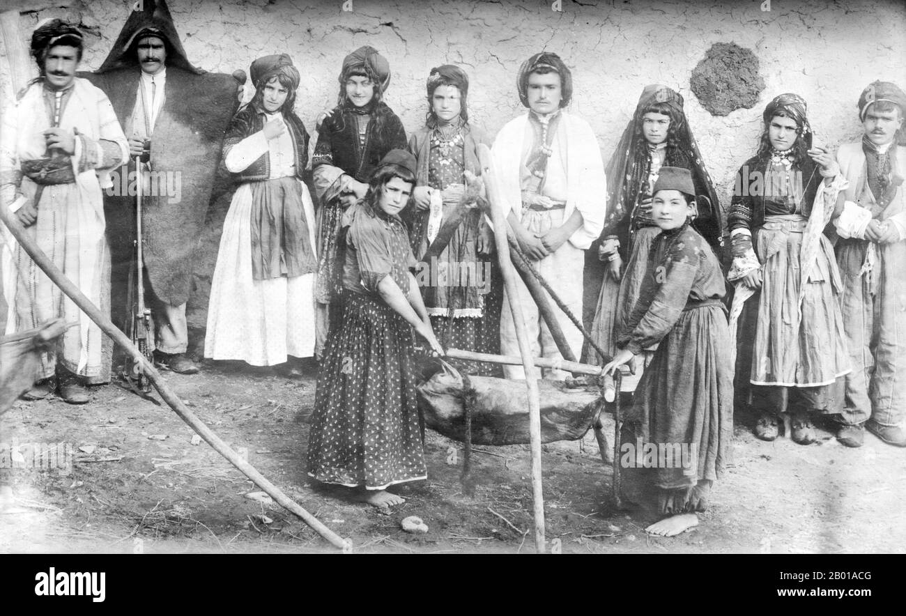 Iran: A Nestorian (Assyrian) Christian family making butter, Mawana, Persia, early 20th century.  The Assyrian Church of the East faced a split in 1898, when a bishop and a number of followers from the Urmia area in Iran entered communion with the Russian Orthodox Church, and again in 1964 when some traditionalists responded to ecclesiastical reforms brought on by Patriarch Mar Eshai Shimun XXIII (1908–1975) by forming the independent Ancient Church of the East.  Today the Assyrian Church has about 170,000 members, mostly living in Iran, Iraq, and Syria. Stock Photo