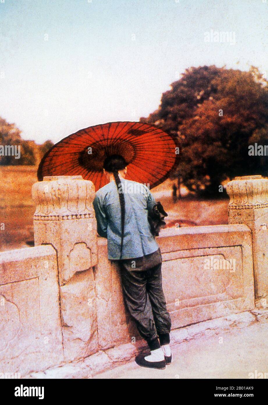 China: A Chinese man with an umbrella and long queue, c. 1900.  The queue (Chinese: Biànzi) was a male hairstyle worn by the Manchus from central Manchuria and later imposed on the Han Chinese during the Qing dynasty. The hairstyle consisted of the hair on the front of the head being shaved off above the temples every ten days and the rest of the hair braided into a long ponytail.  The hairstyle was compulsory for all males and the penalty for not having it was execution as it was considered treason. After the fall of the Qing dynasty, the Chinese no longer had to wear the queue. Stock Photo